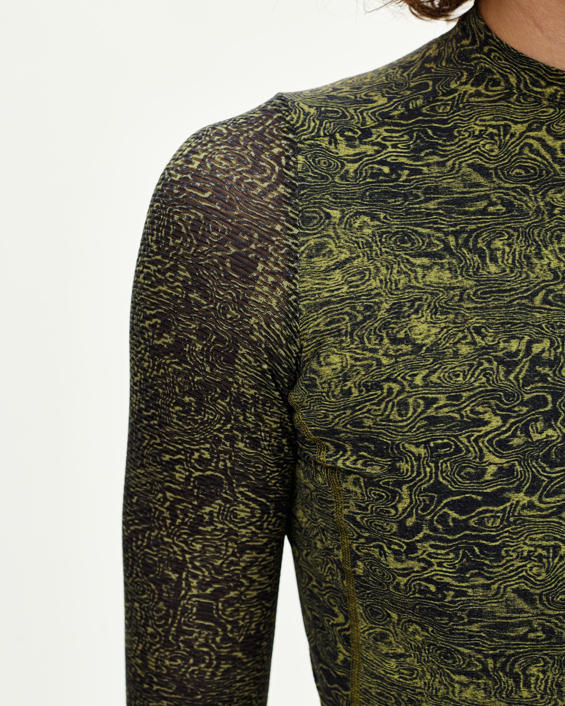 Dark Lime Essential long sleeve cycling jersey, detail view on model with all-over swirl print
