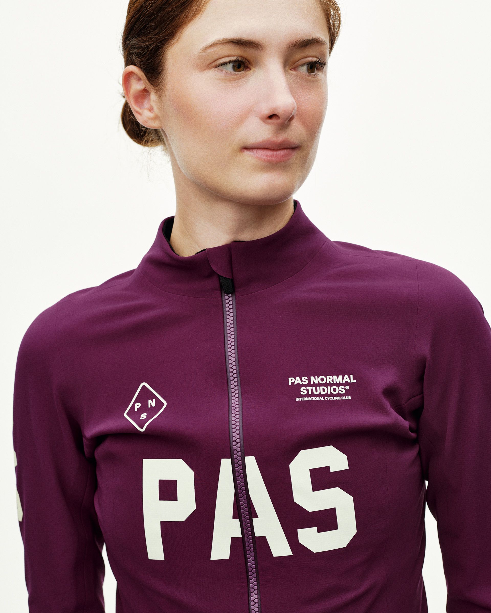 Dark Purple PAS Mechanism Thermal cycling jacket on model, front detail with large cream PAS chest print