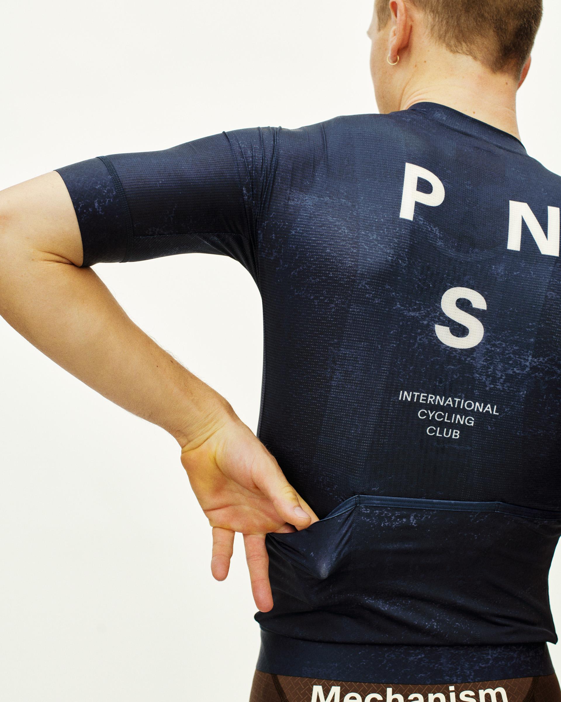 Navy Mechanism cycling jersey on model, rear view with white PNS logo and back pockets