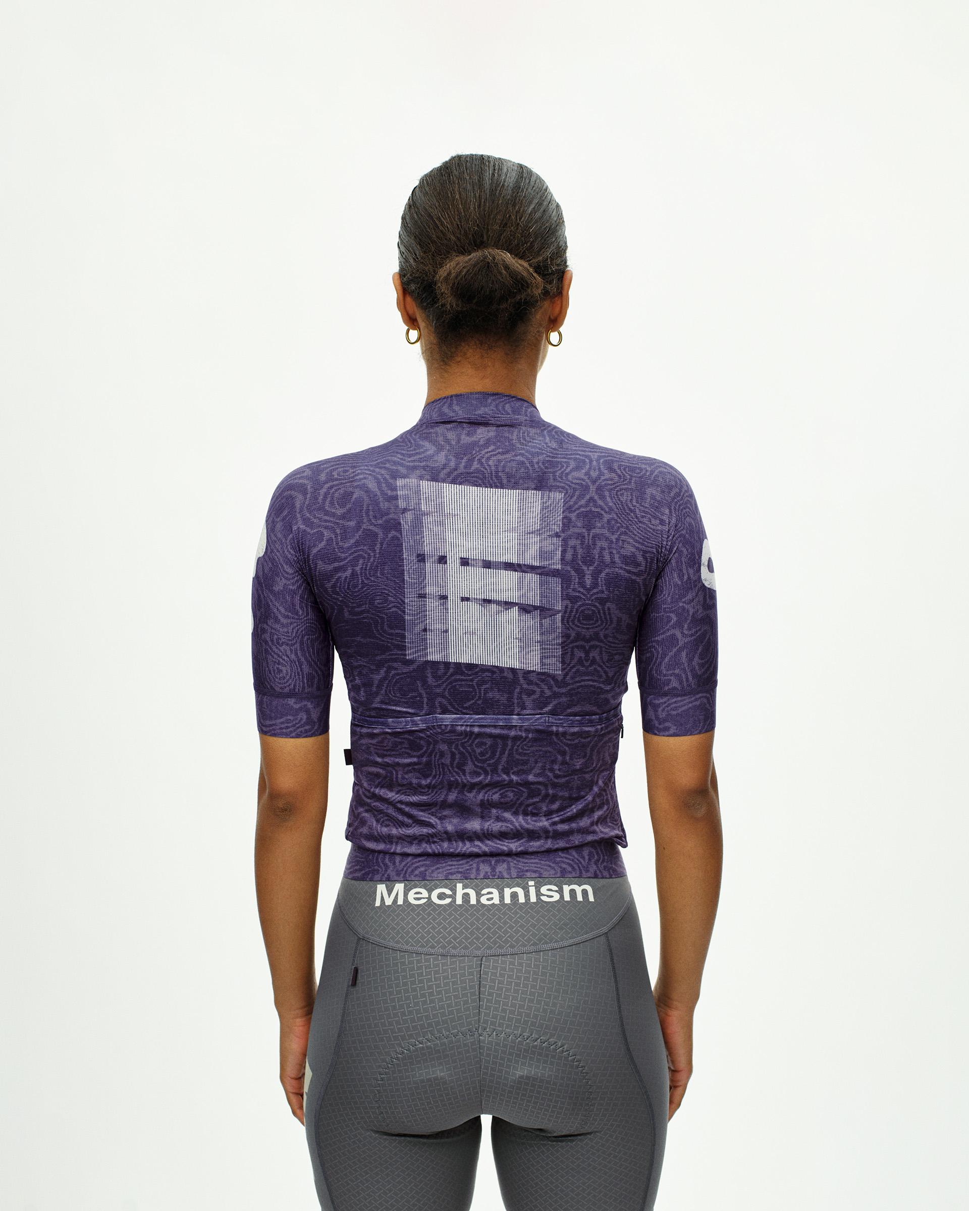 Purple Mechanism women's cycling jersey, rear view on model with all-over moire print and white graphic back panel