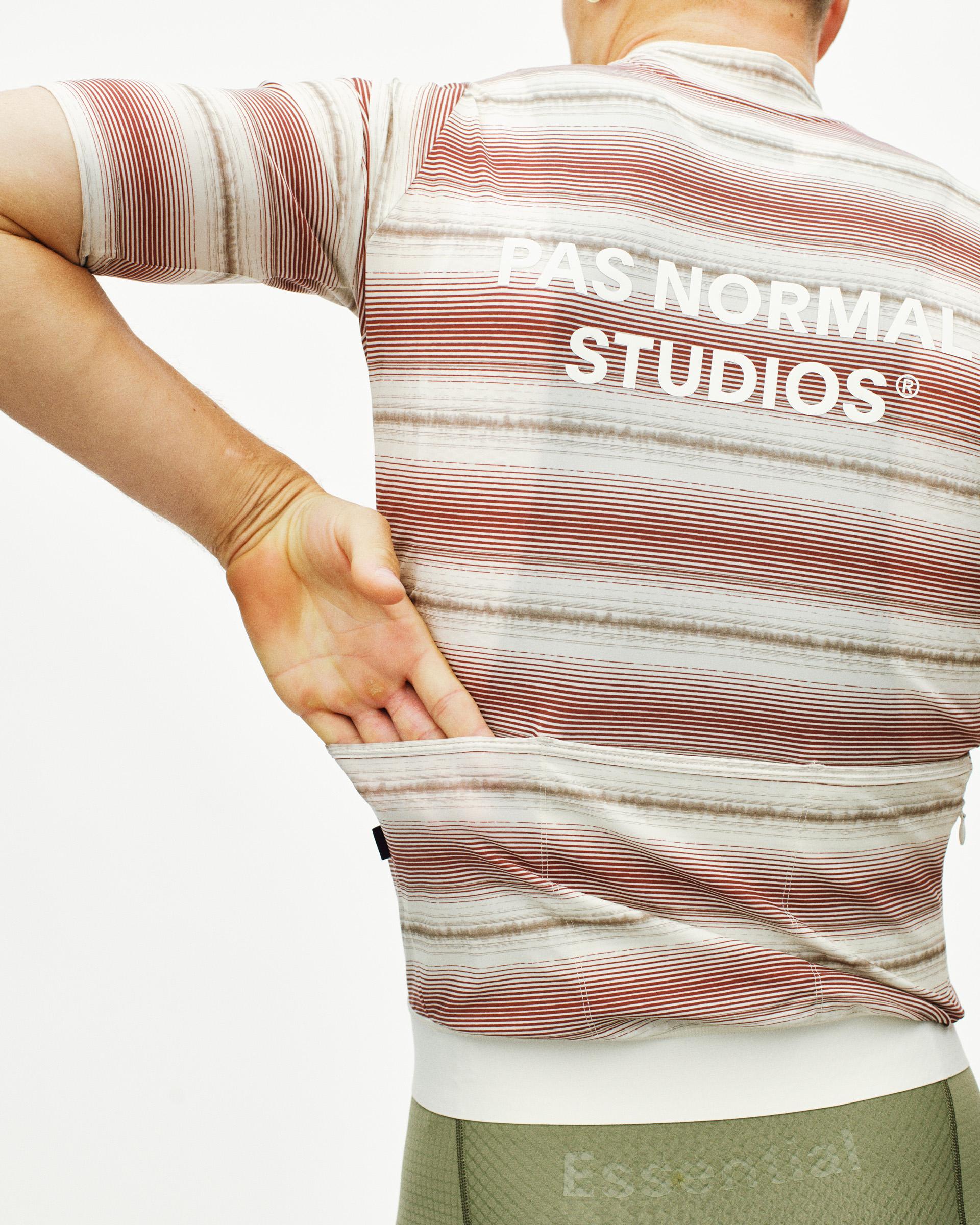 White Essential cycling jersey on model, rear view with red and brown horizontal stripes