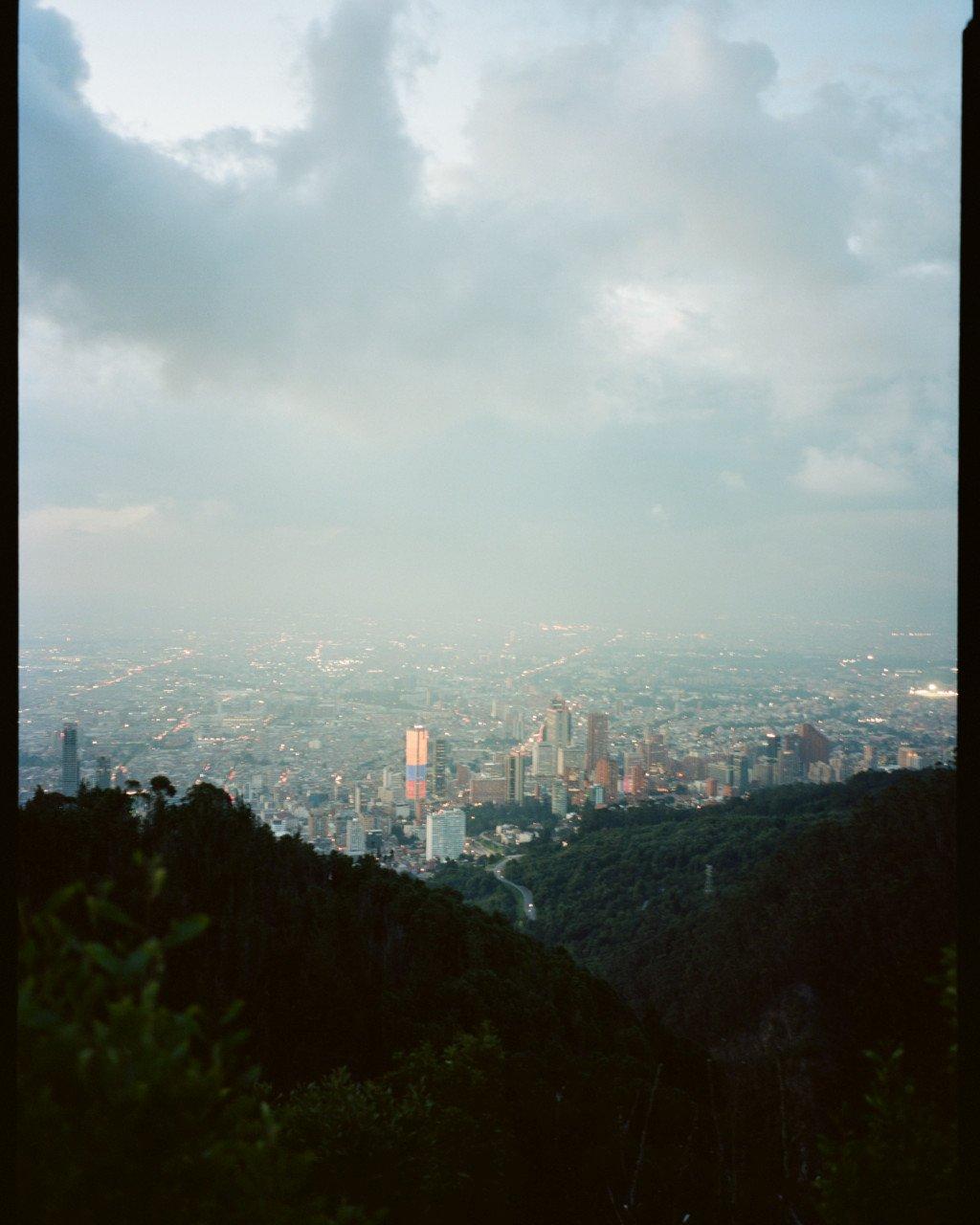 City skyline view from hillside overlooking Bogotá with cloudy sky