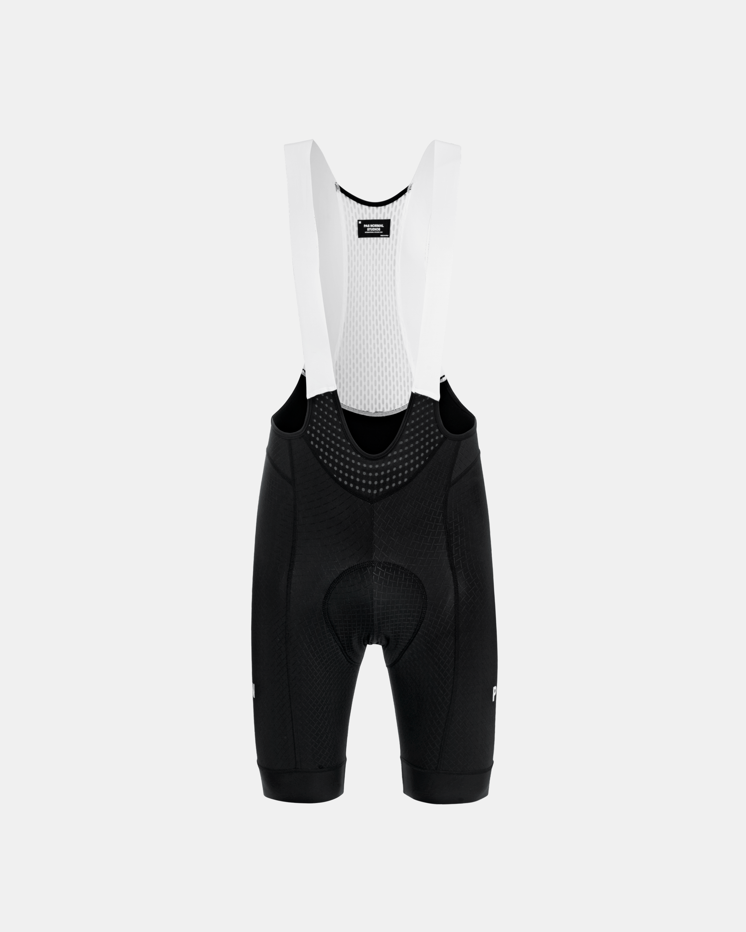 Black Mechanism cycling bibs, front flat lay with white mesh panel and perforated bib straps