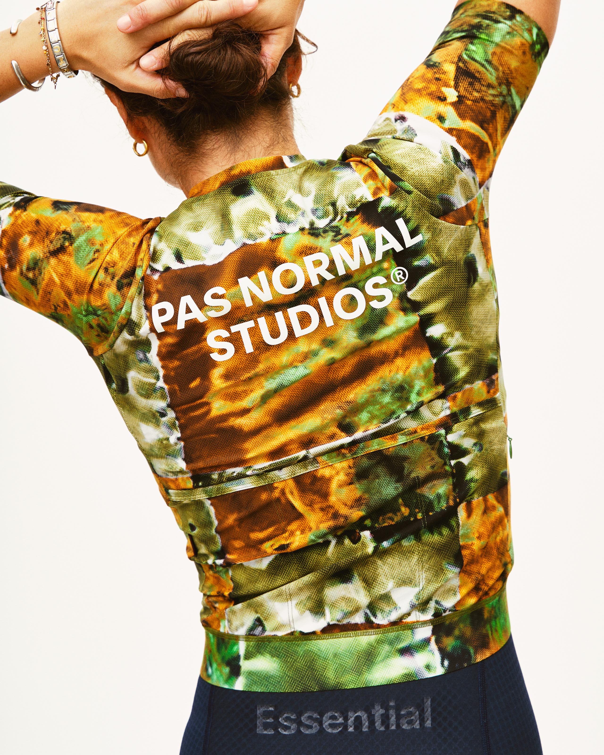 Green Essential cycling jersey on model, rear view with kaleidoscope print and white logo