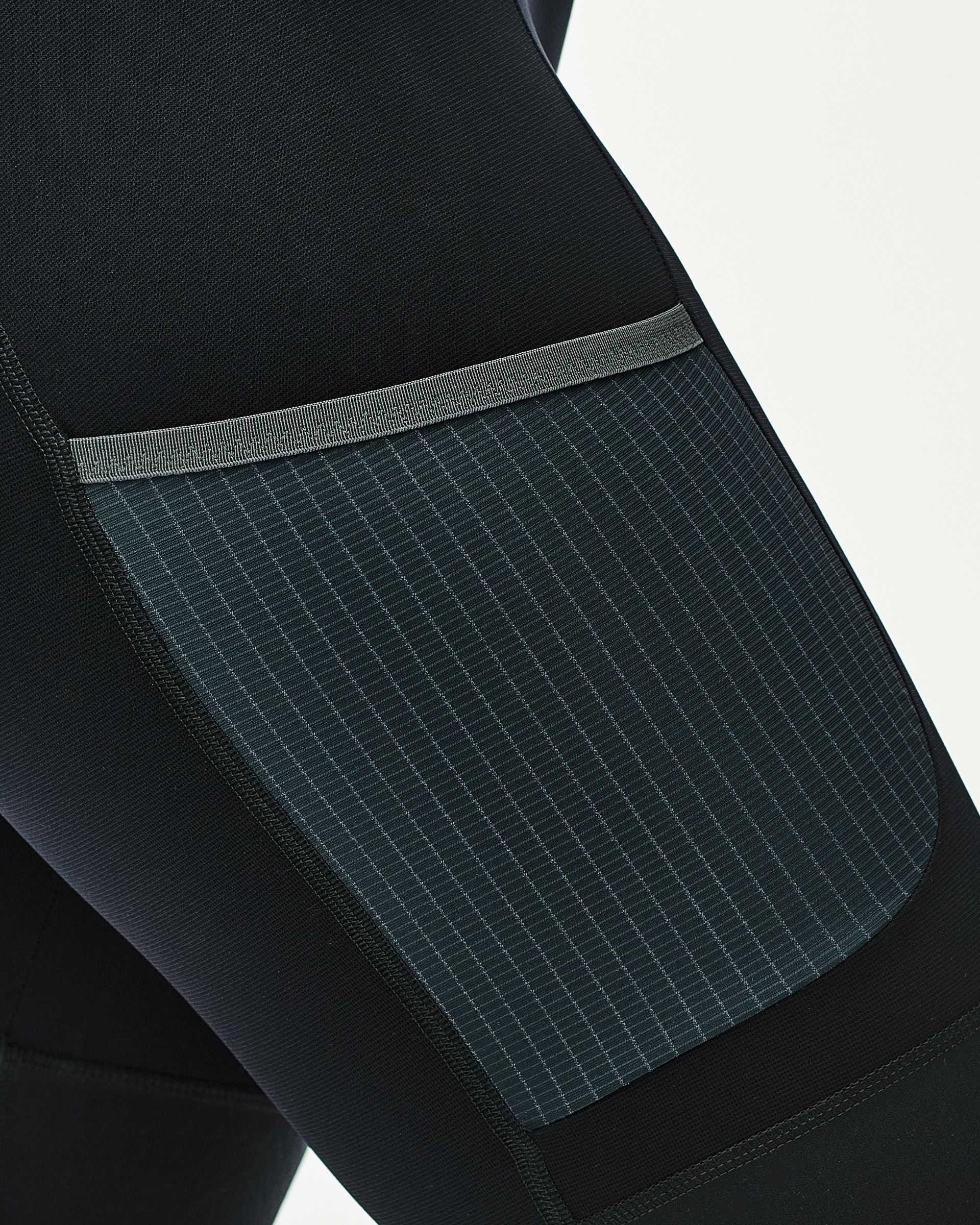 Cargo pocket with tilted opening and grid-patterned fabric panel on cycling shorts leg