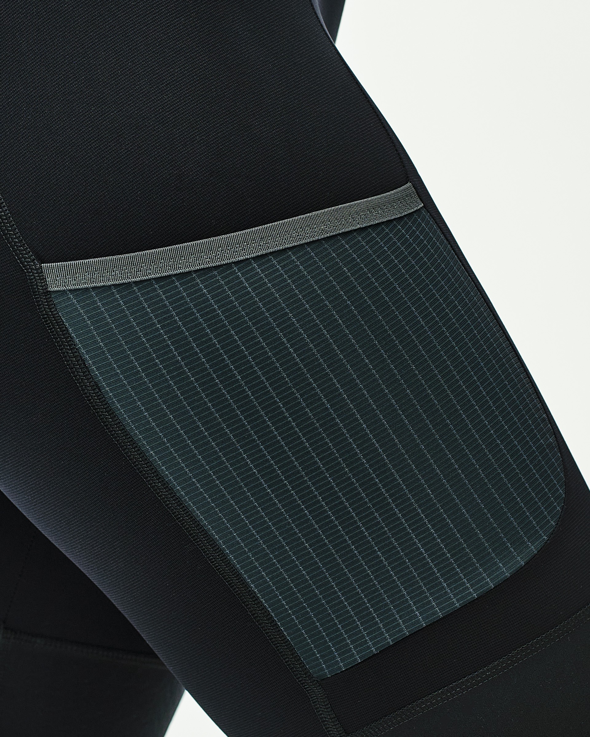 Cargo pocket with tilted opening and grid-patterned fabric panel on cycling shorts leg