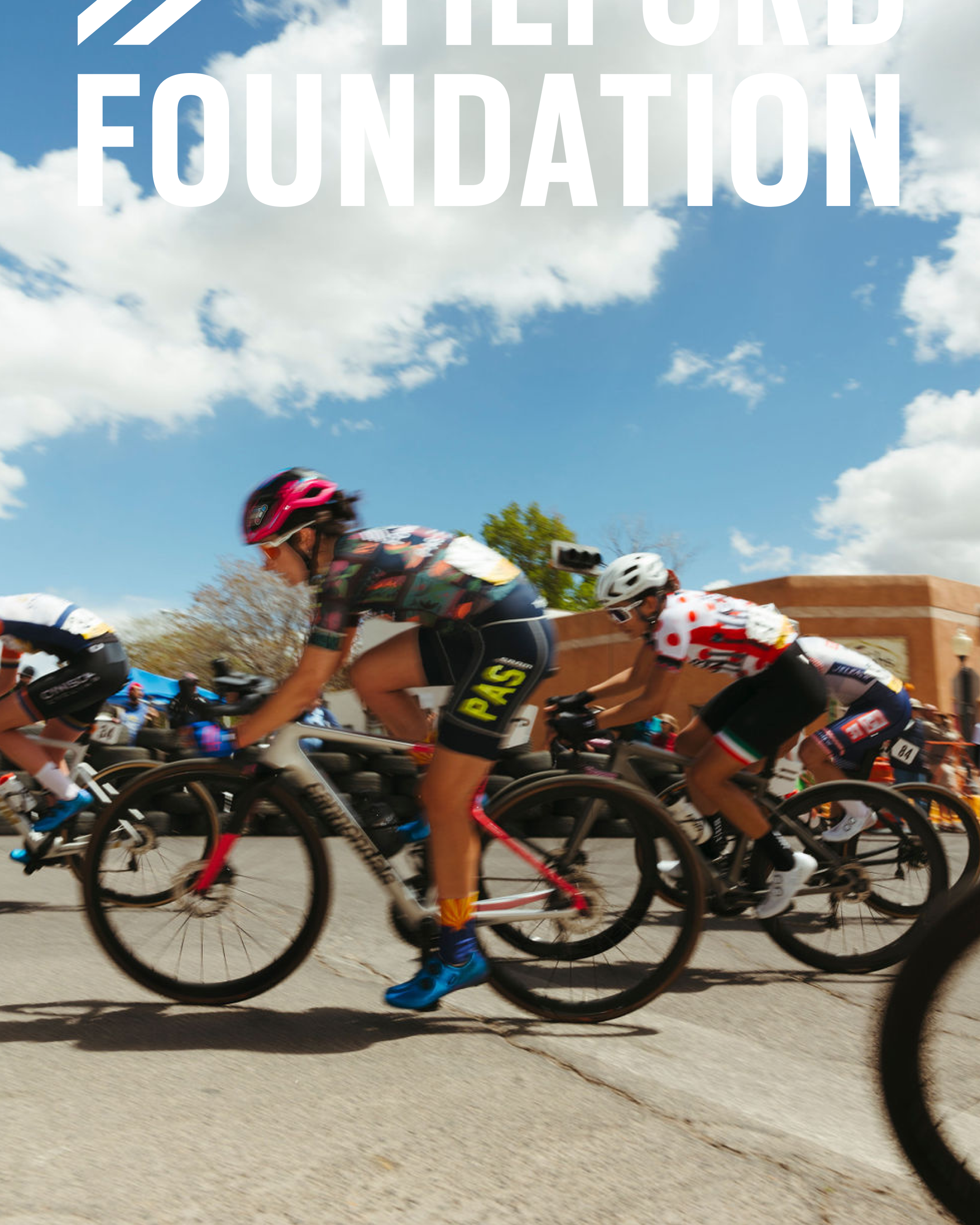 Cyclists racing in peloton with blue sky and white text overlay reading "The Foundation"