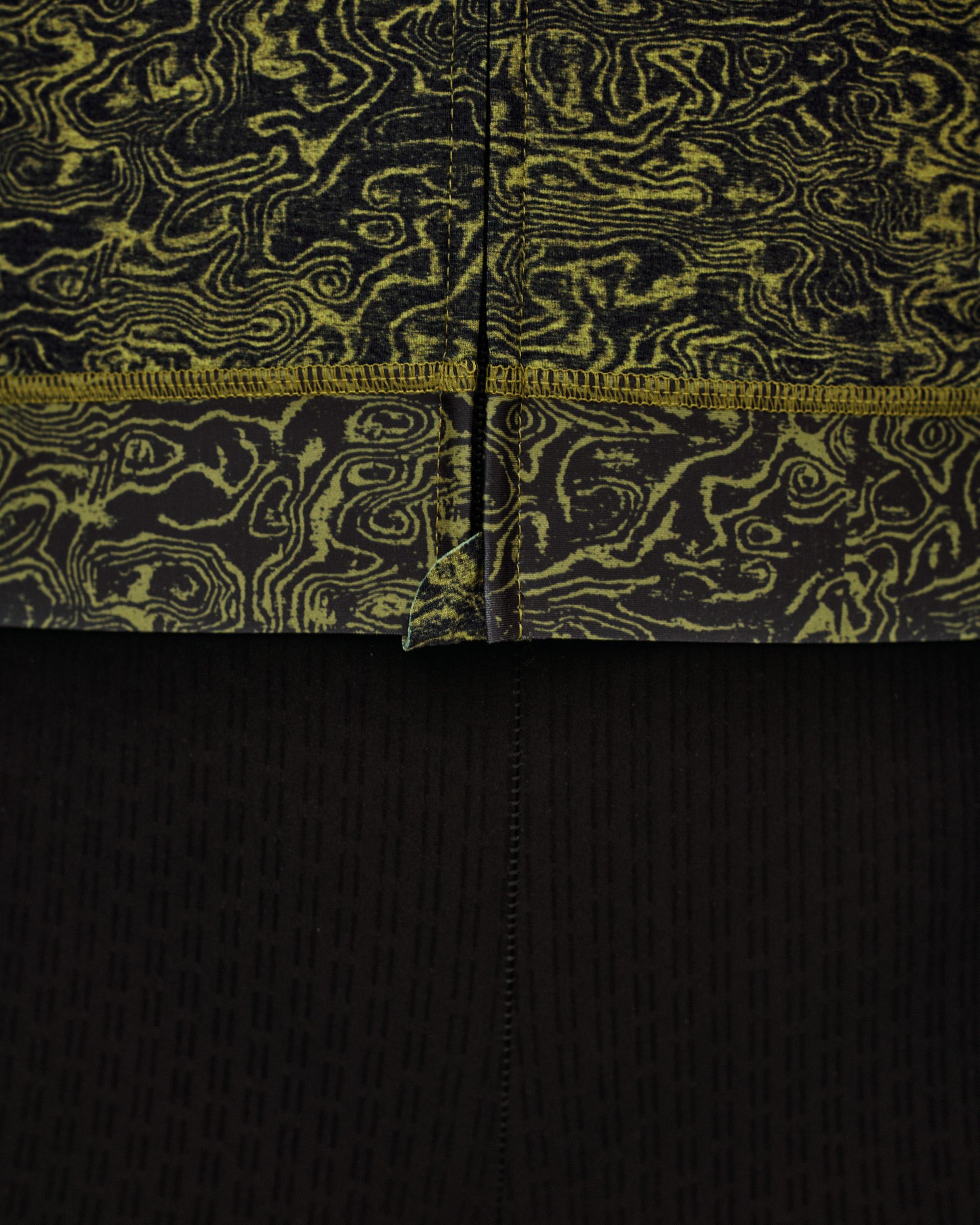Dark Lime Essential women's cycling jersey, detail view of hem with contour print and contrast overlock stitching