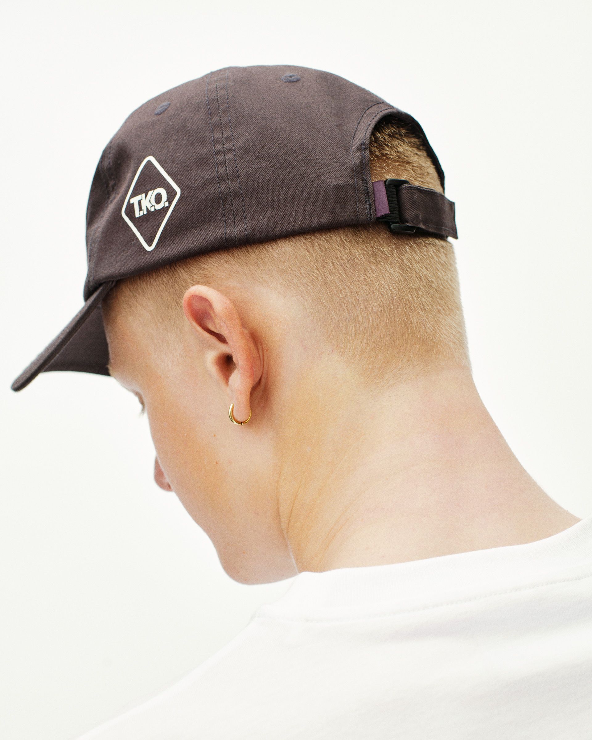 Dark Purple T.K.O. Off-Race cap on model, rear view with diamond logo patch and clip adjuster