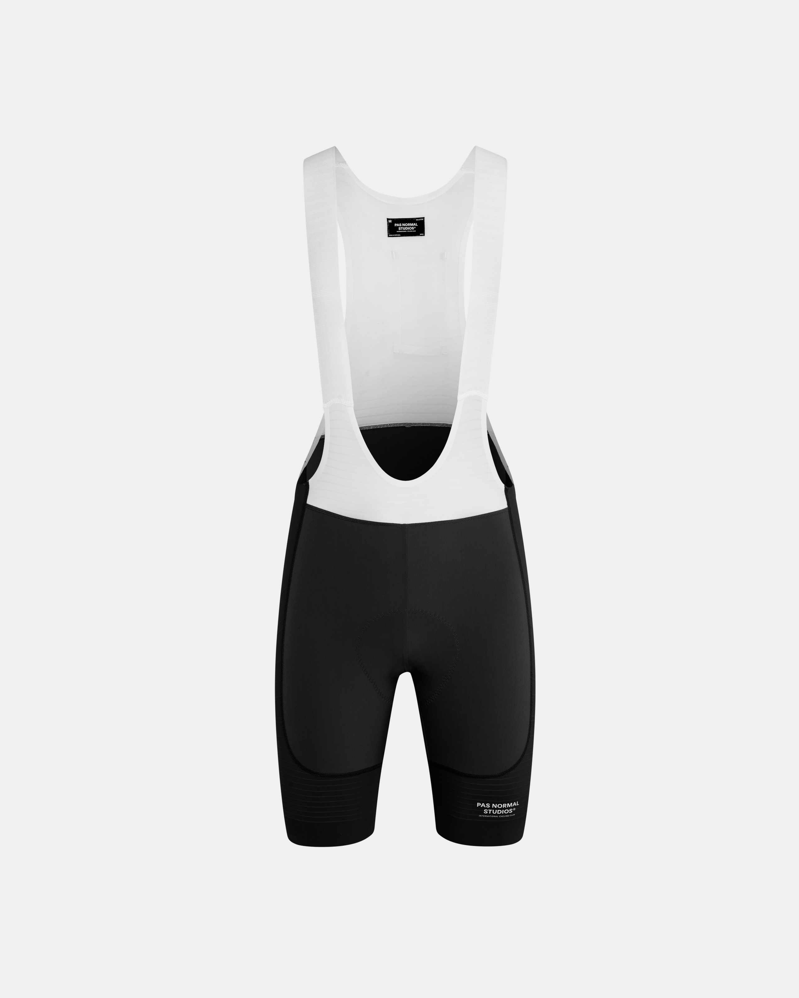 Black Mechanism Pro cycling bibs, front flat lay with white bib straps and black shorts