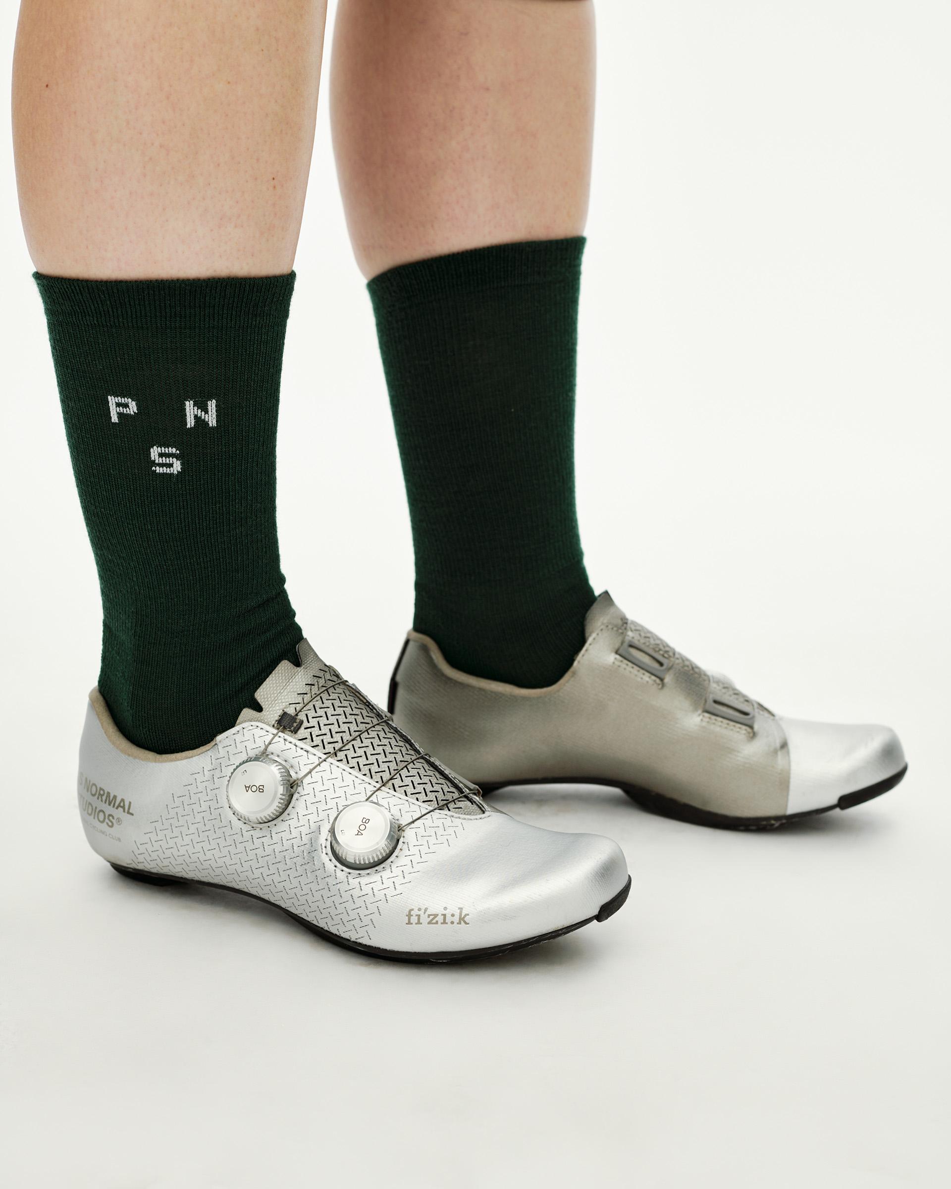 Petroleum green Essential Thermal Wool cycling socks on model, side view with white logo knit detail