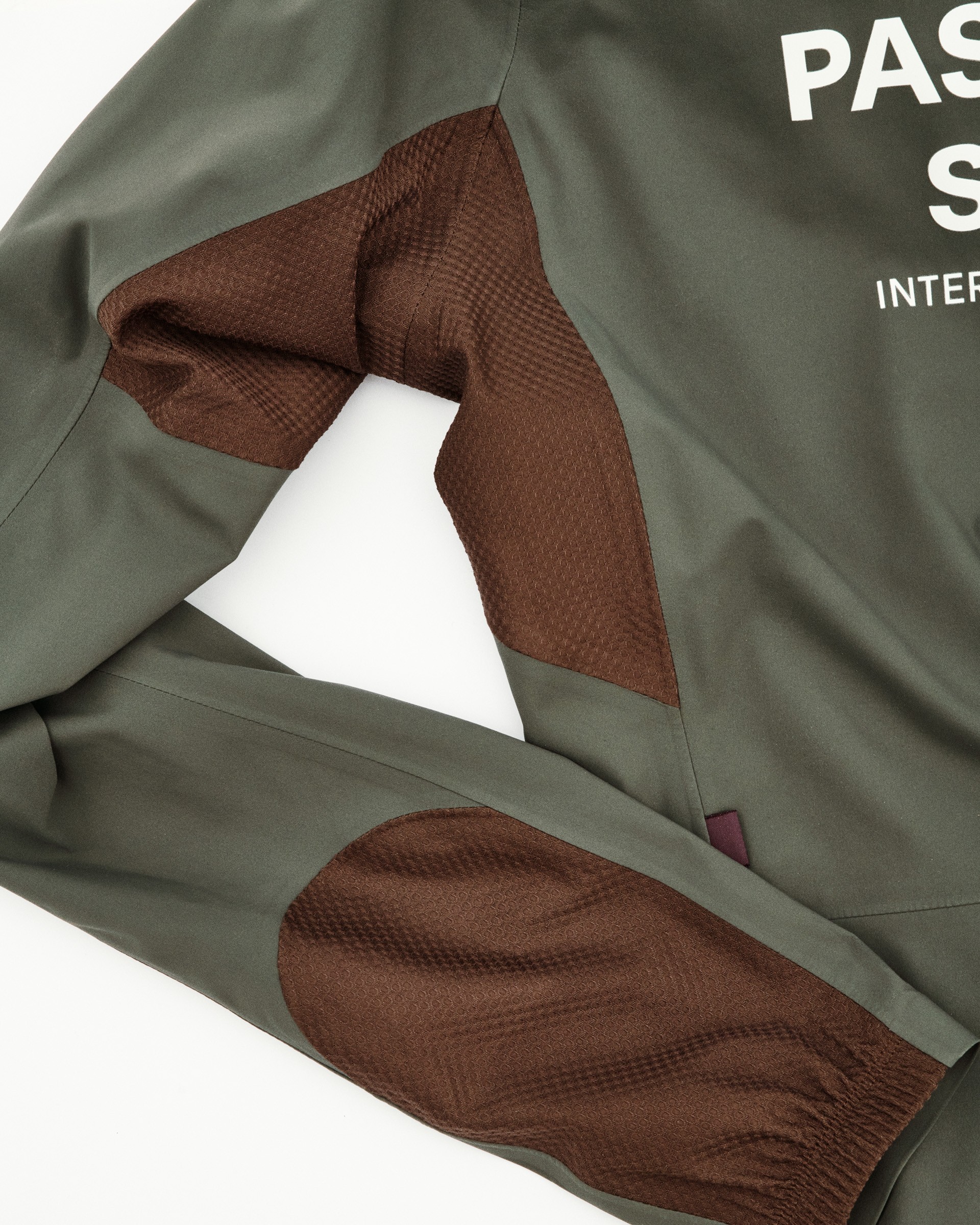 Brown mesh stretch panels on jacket armpit and side seam areas for enhanced ventilation and movement