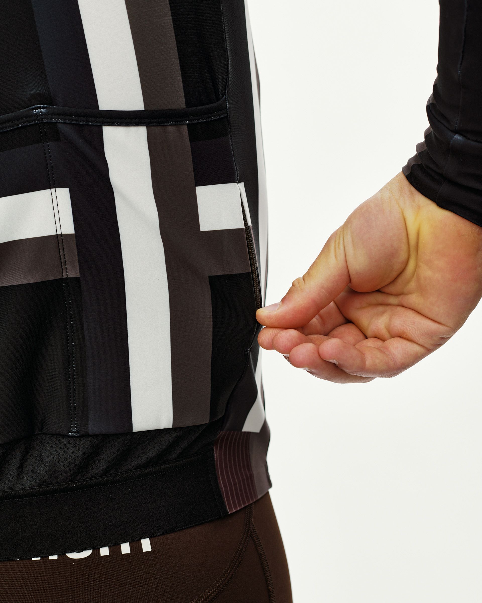 International Dark Olive Mechanism long sleeve cycling jersey, side detail on model with zip rear pocket and stripe print