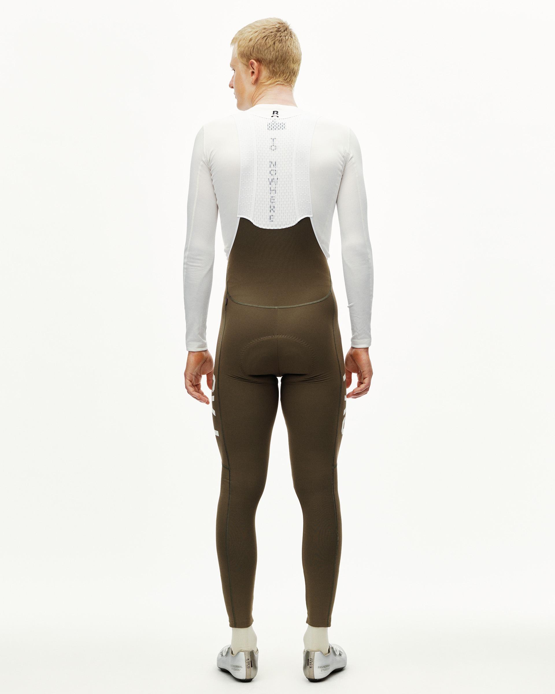 Dark Earth khaki PAS Mechanism Thermal Long cycling bib tights on model, rear view with reflective ankle details