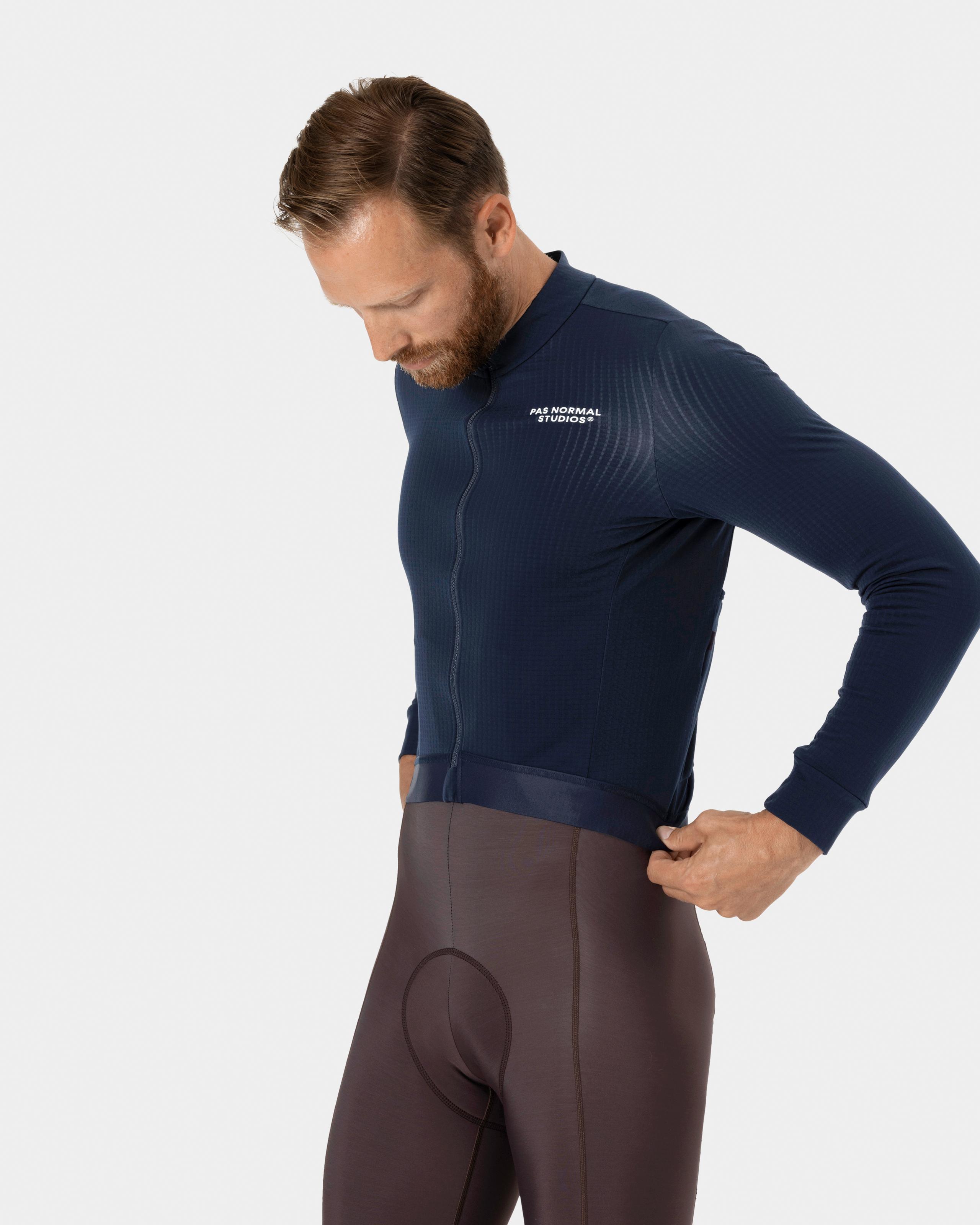 Navy Essential long sleeve cycling jersey on model with ribbed chest panel and white logo