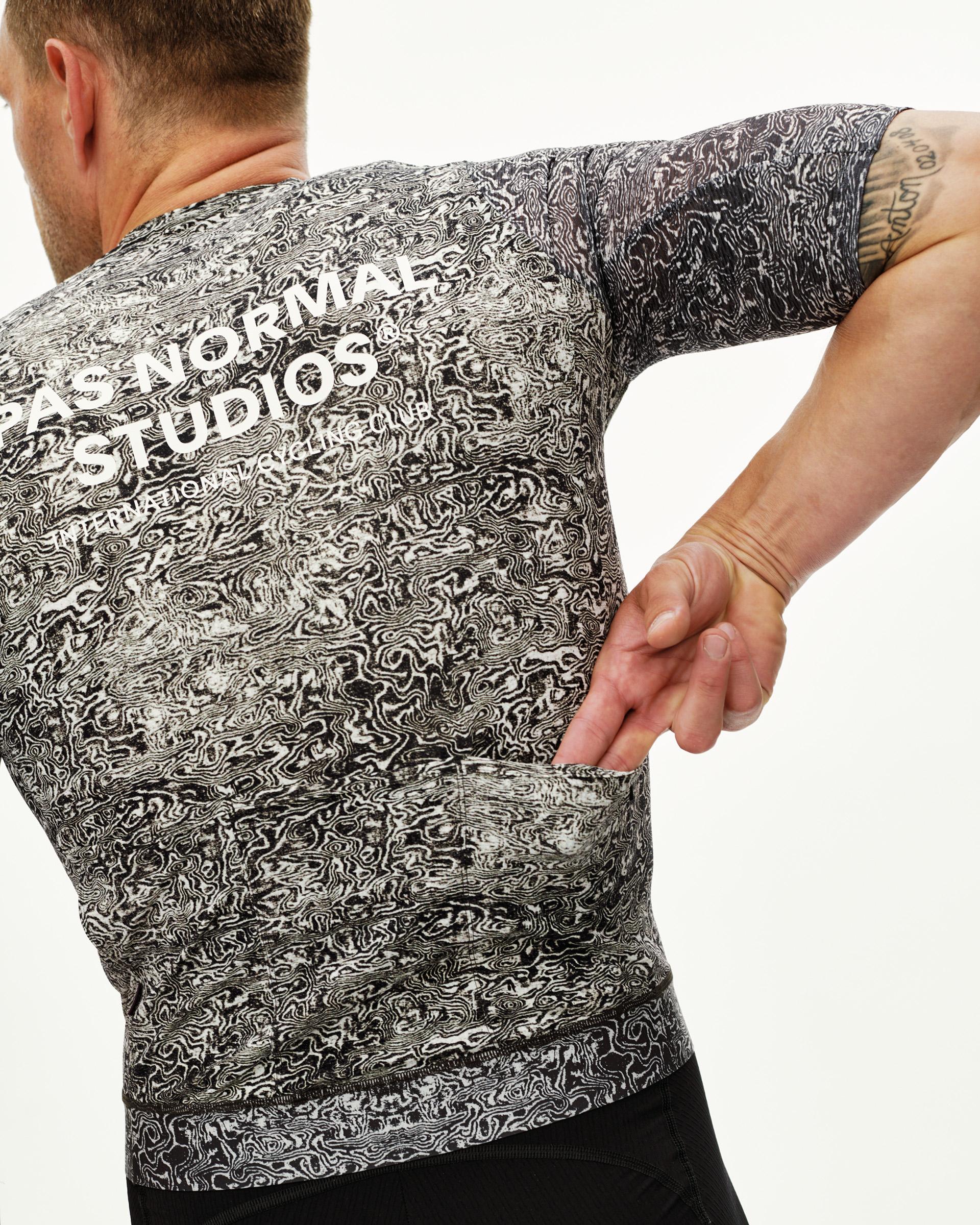 Off White Essential cycling jersey on model, rear view with black swirl all-over print and back pockets