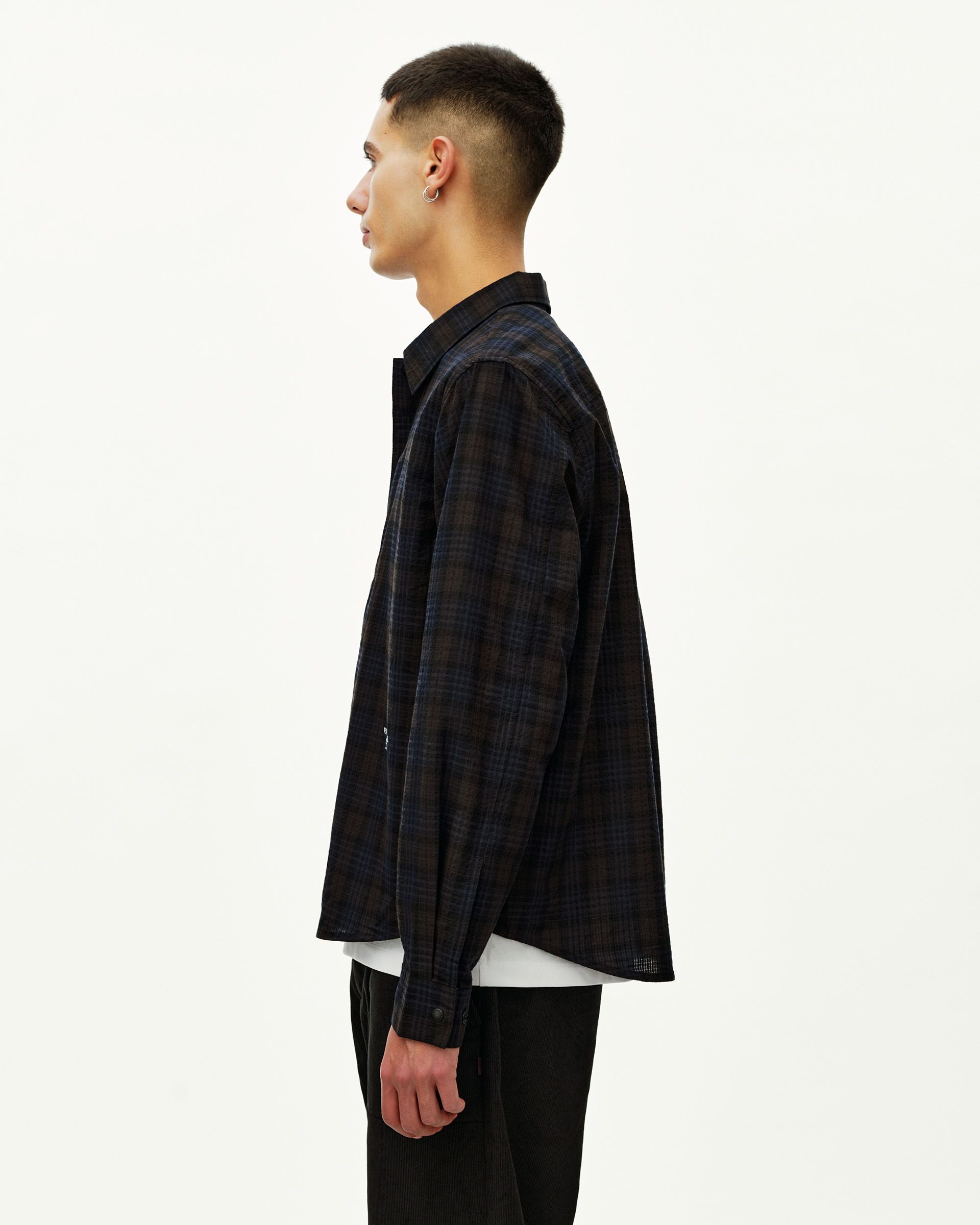 Dark Navy Off-Race Seersucker shirt on model, side view with plaid pattern and button cuff