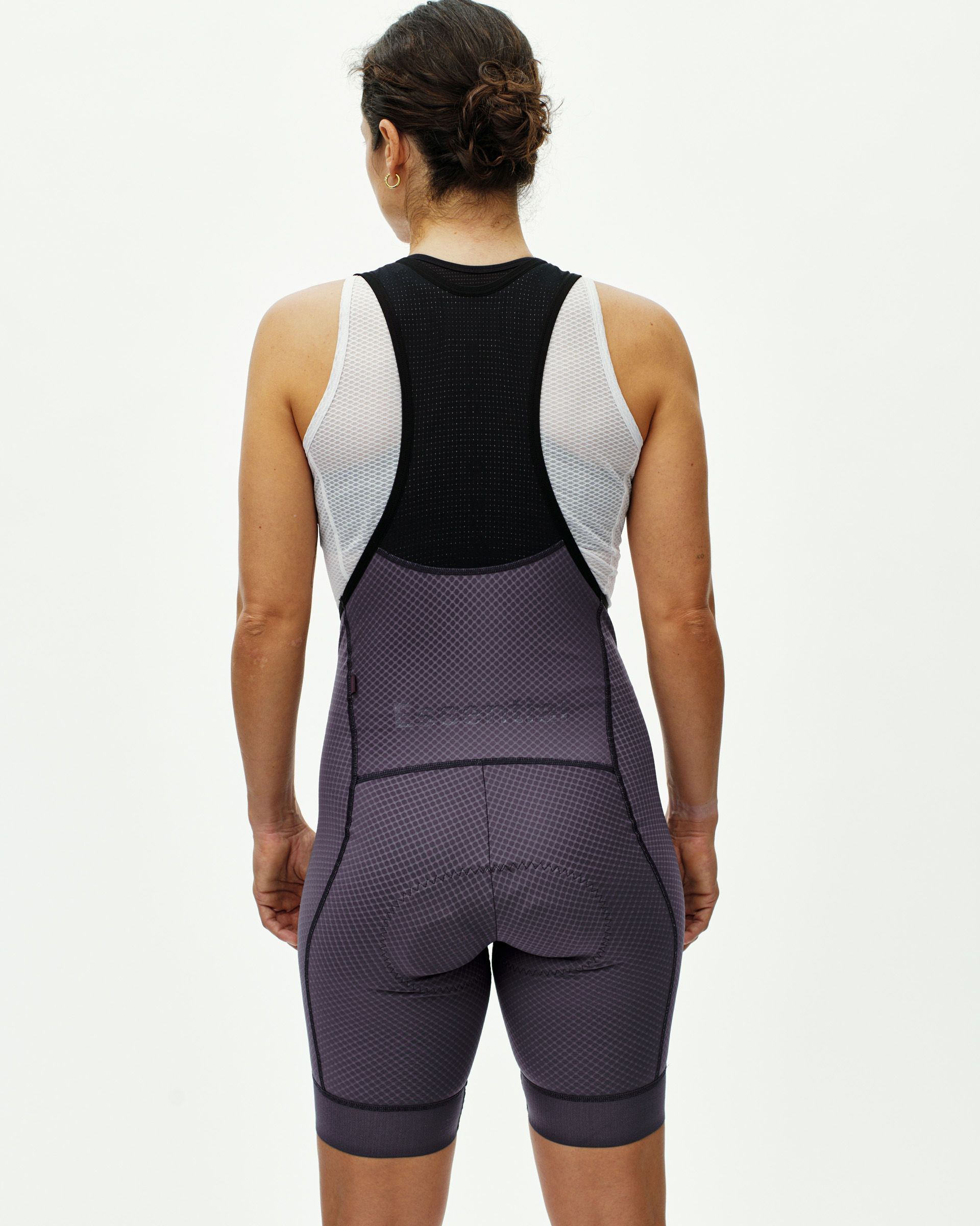 Grey Essential cycling bibs on model, rear view with white mesh back panel and textured fabric