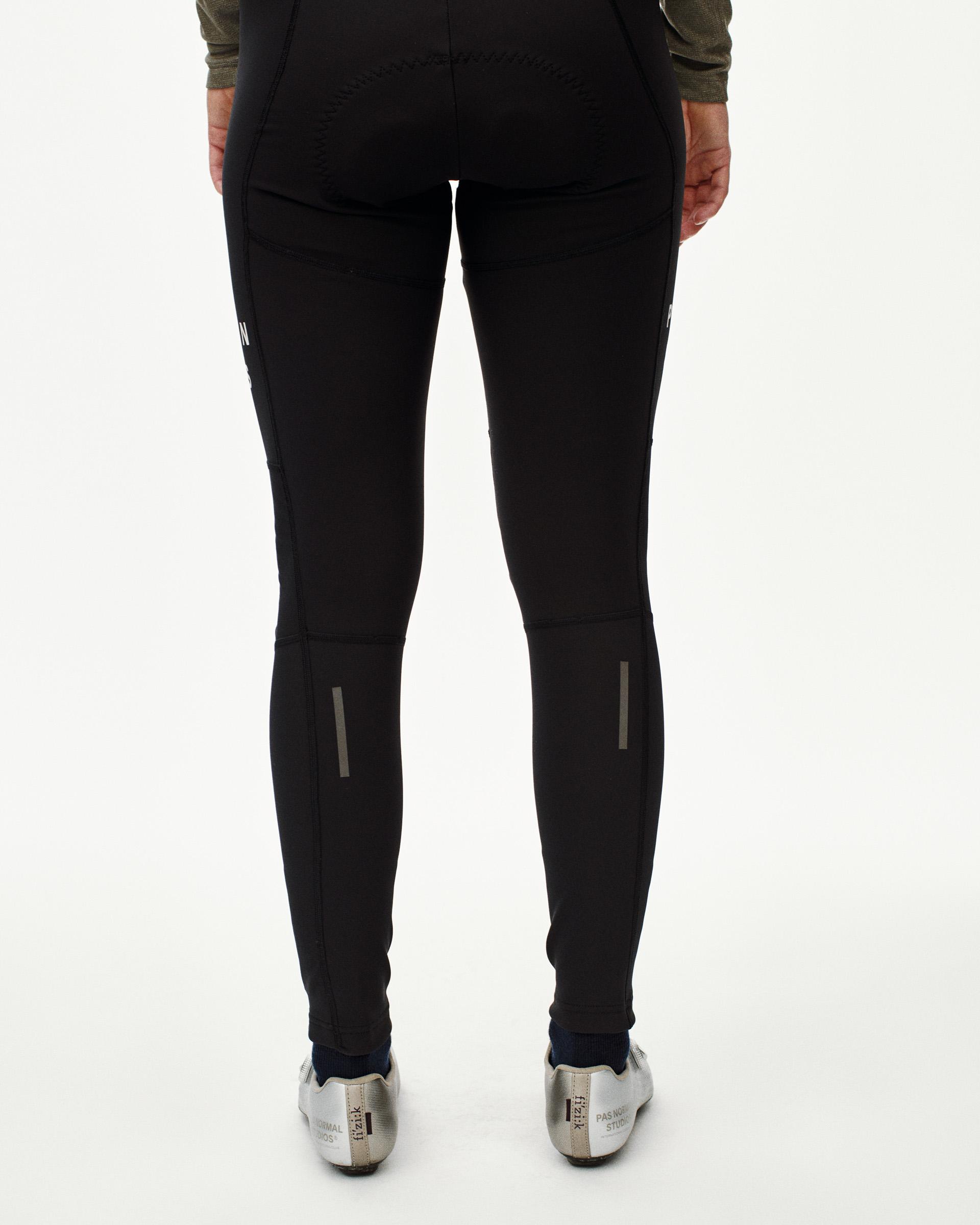 Black Mechanism Deep Winter Long cycling bibs on model, rear view with reflective ankle zips
