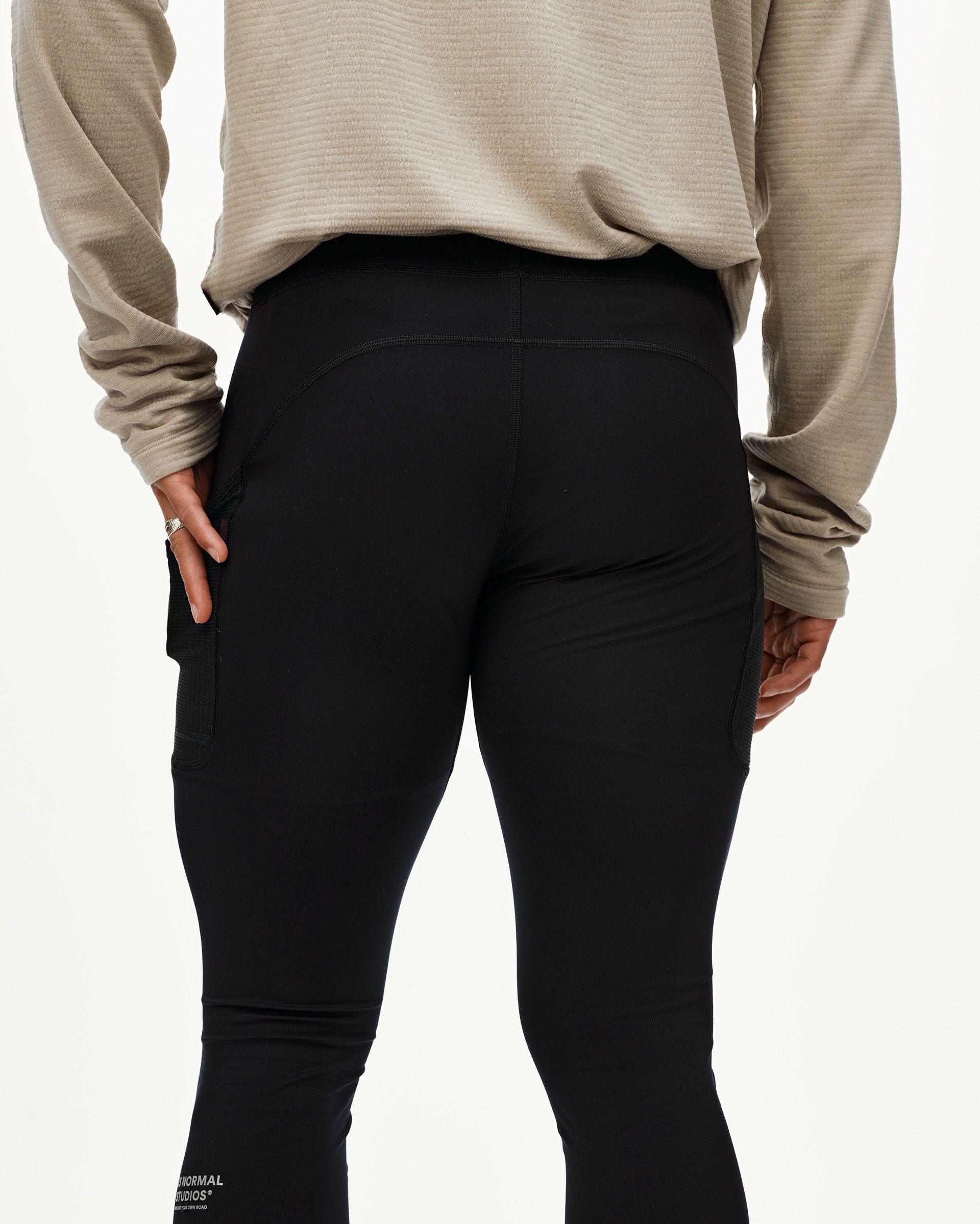 Black Balance long cycling tights on model, rear view with side mesh panels and wide waistband
