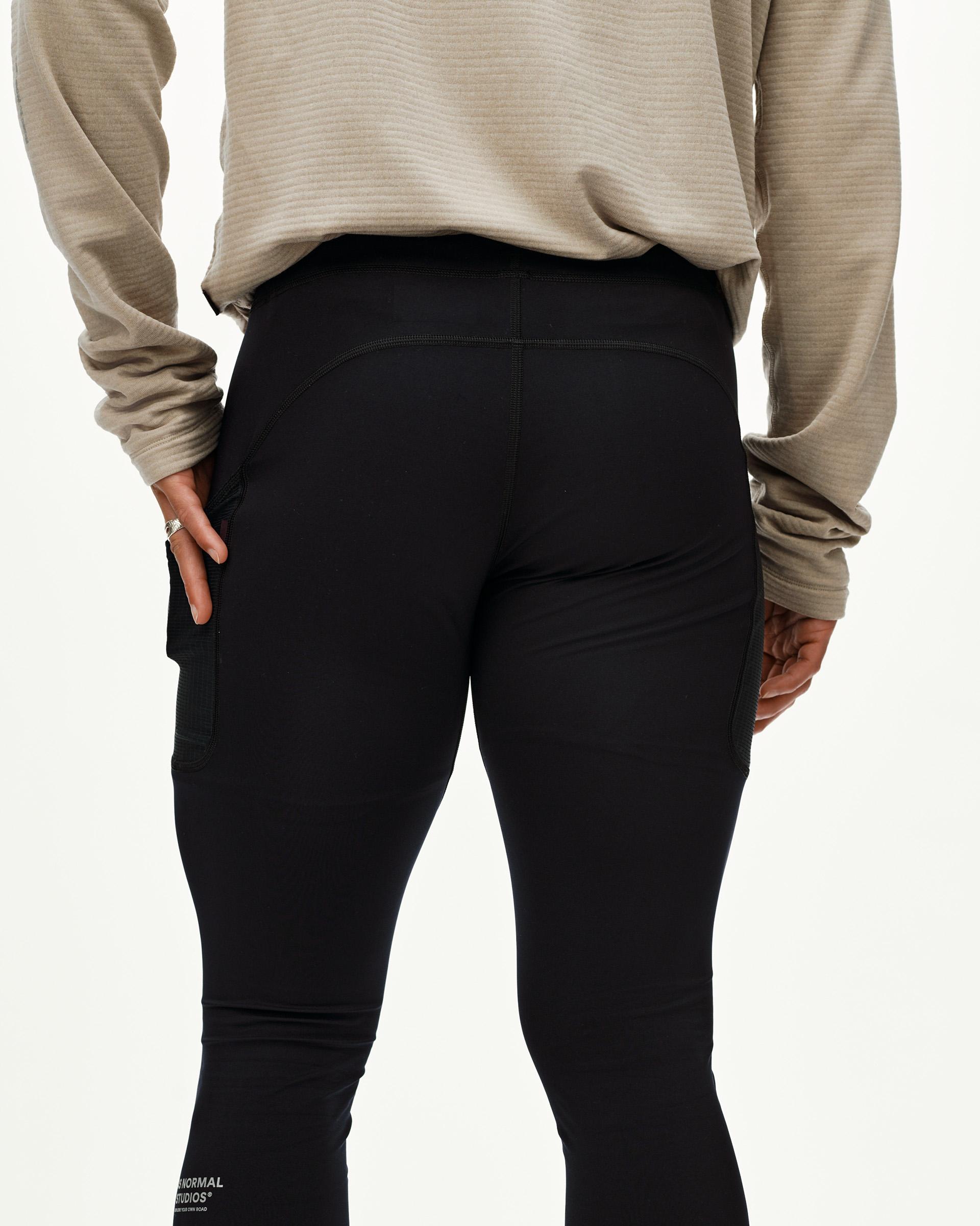 Black Balance long cycling tights on model, rear view with side mesh panels and wide waistband