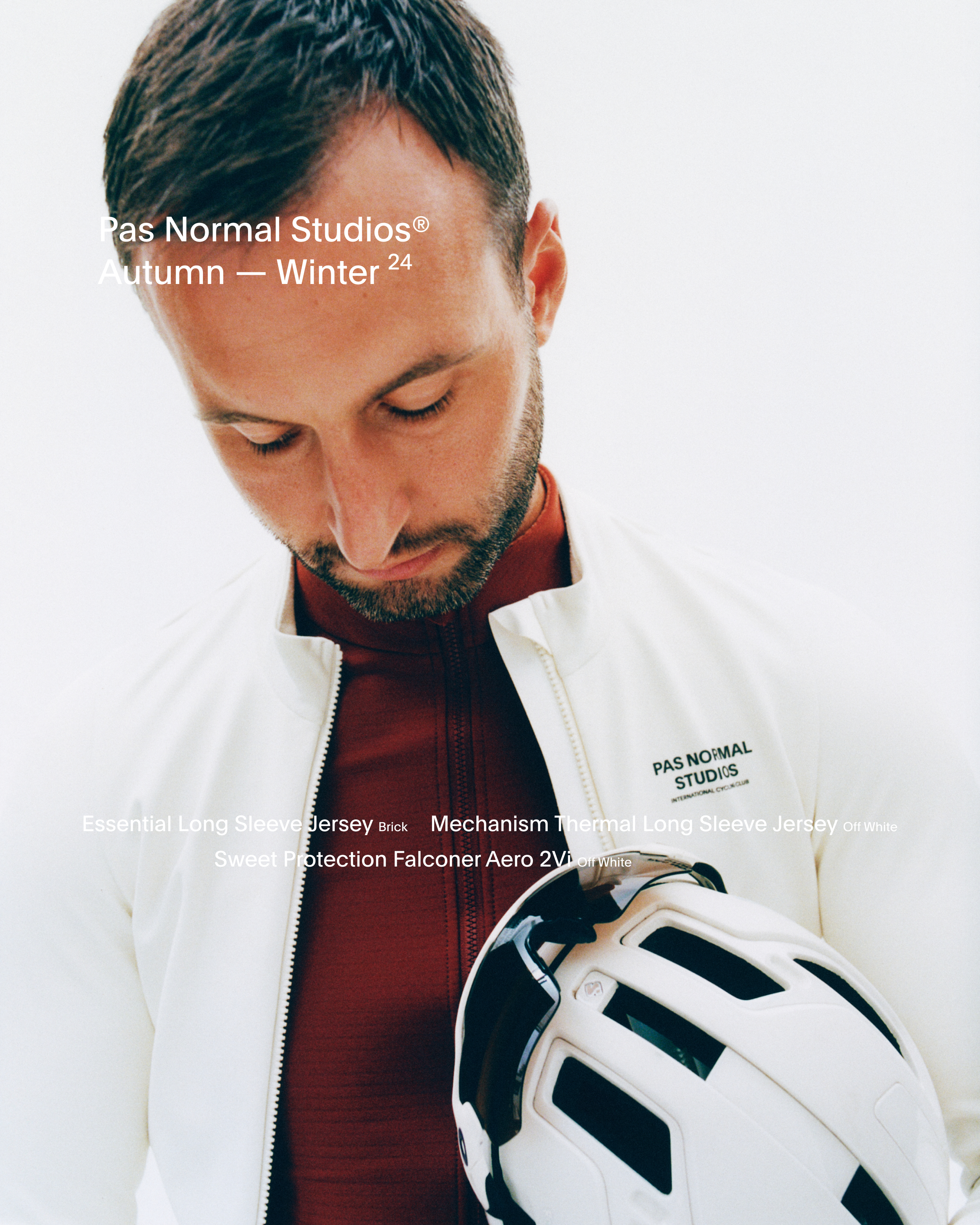 Model wearing white cycling jacket over red base layer, holding white helmet for Autumn Winter 2024 collection