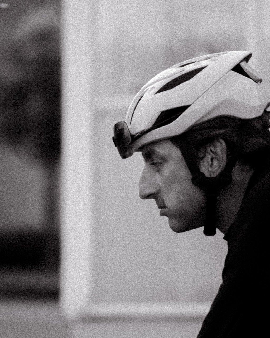 Cyclist in profile wearing white aerodynamic cycling helmet, black and white photography