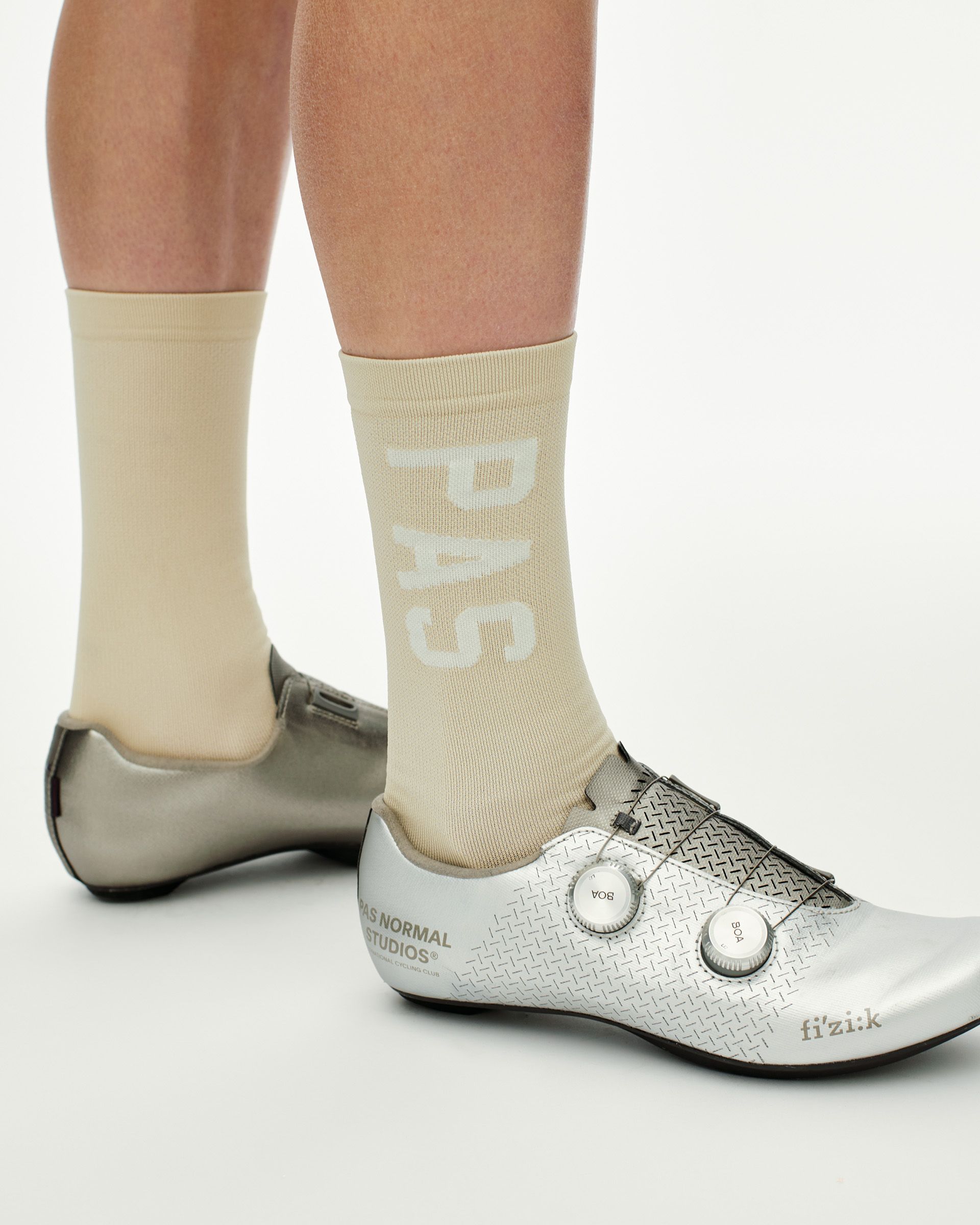 Cream PAS cycling socks on model with white PAS branding