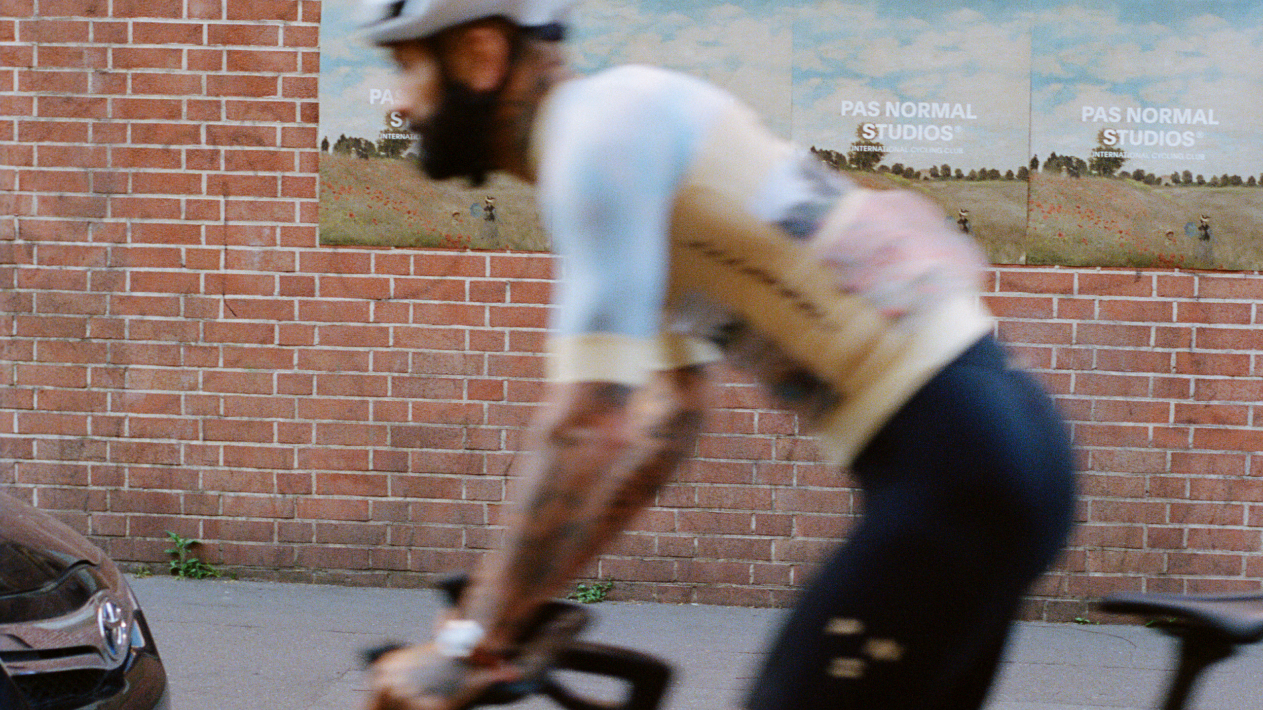 White JJJJound sleeveless base layer on cyclist in motion blur