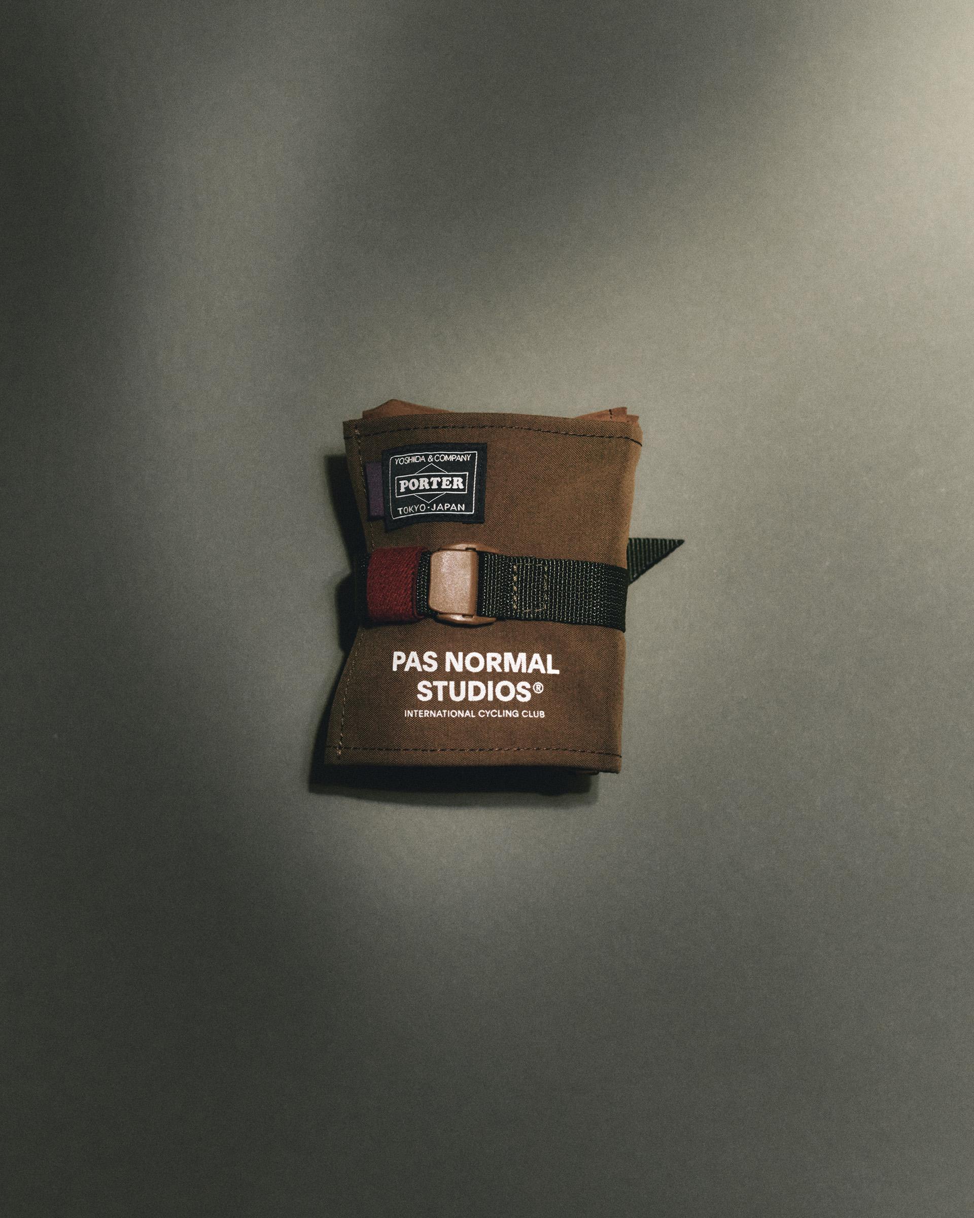 Light Brown Porter-Yoshida saddle bag, flat lay folded with buckle strap and woven logo patch