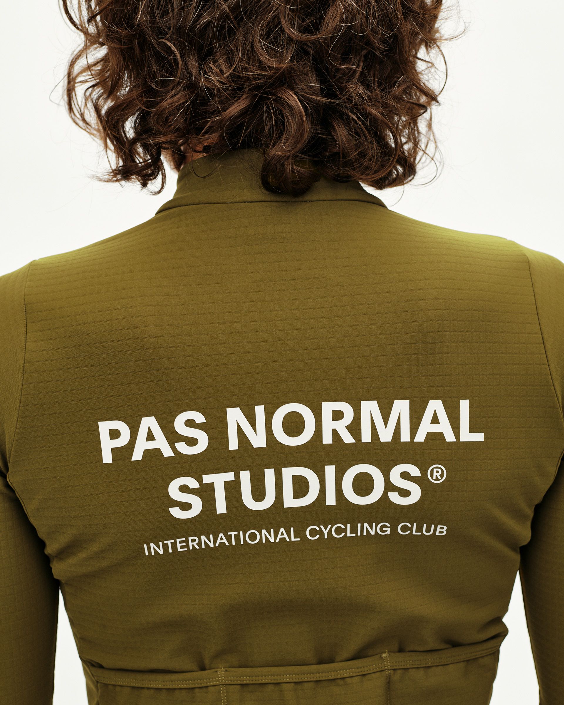 Khaki Green Essential long sleeve cycling jersey on model, rear view with white back print