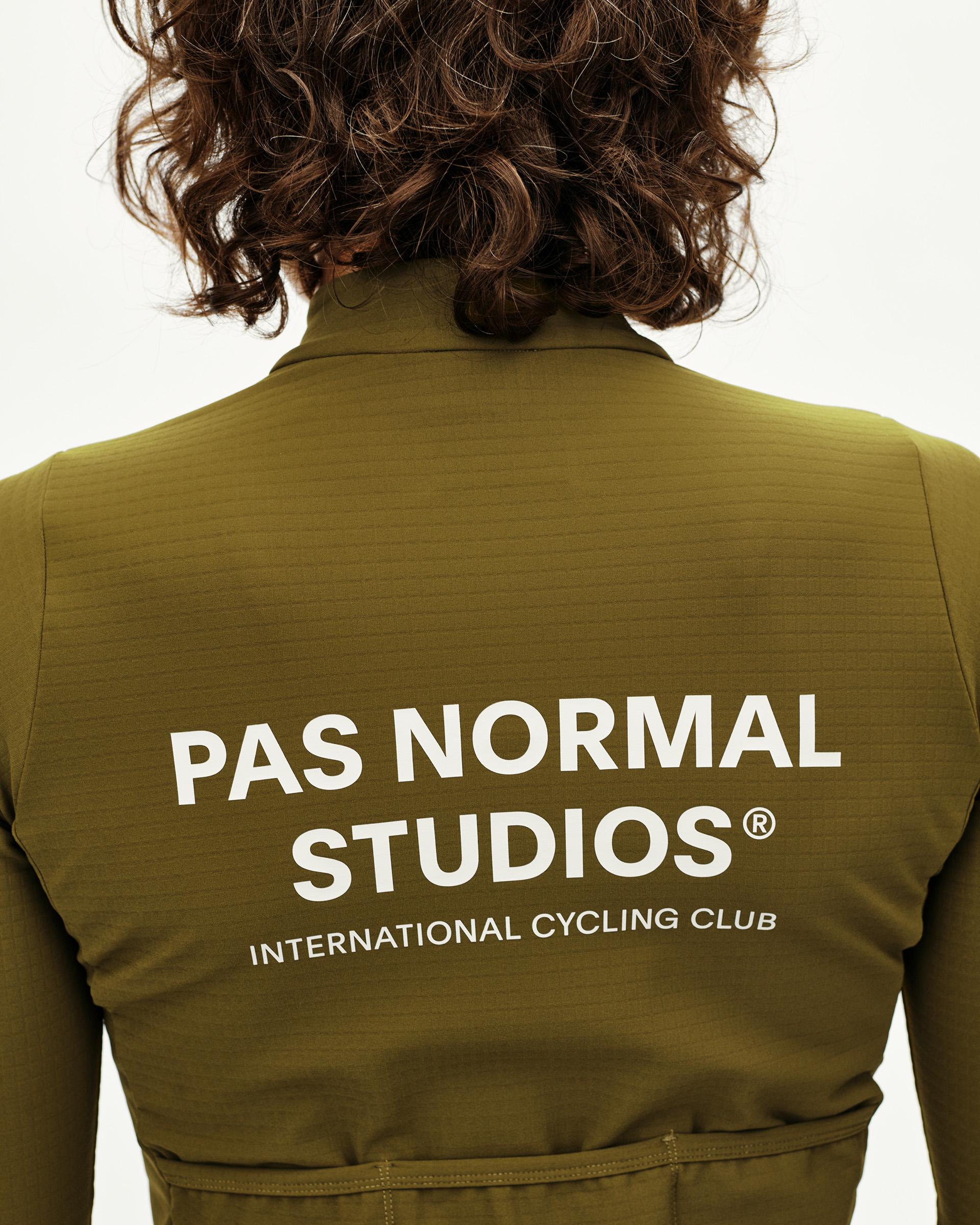 Khaki Green Essential long sleeve cycling jersey on model, rear view with white back print