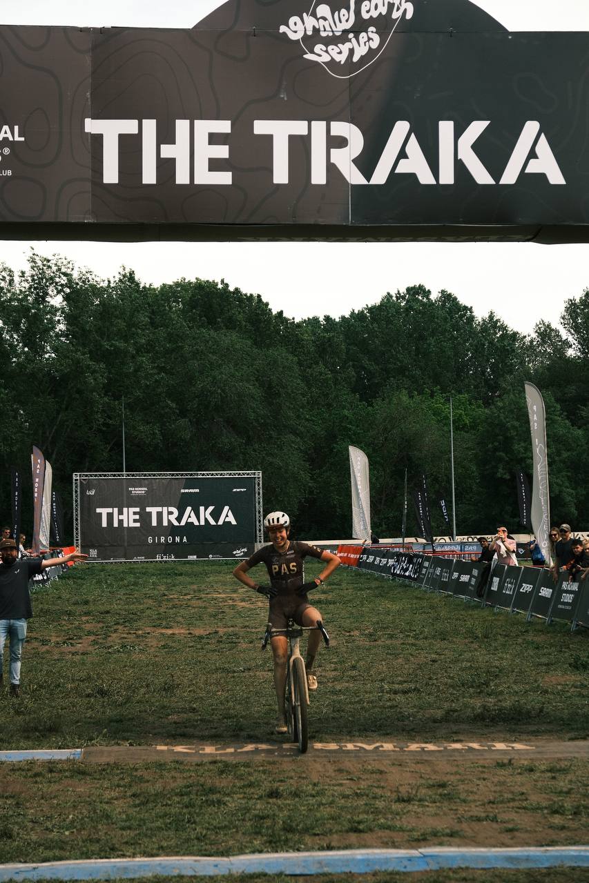 Cyclist wearing dark kit crossing finish line at The Traka gravel race event