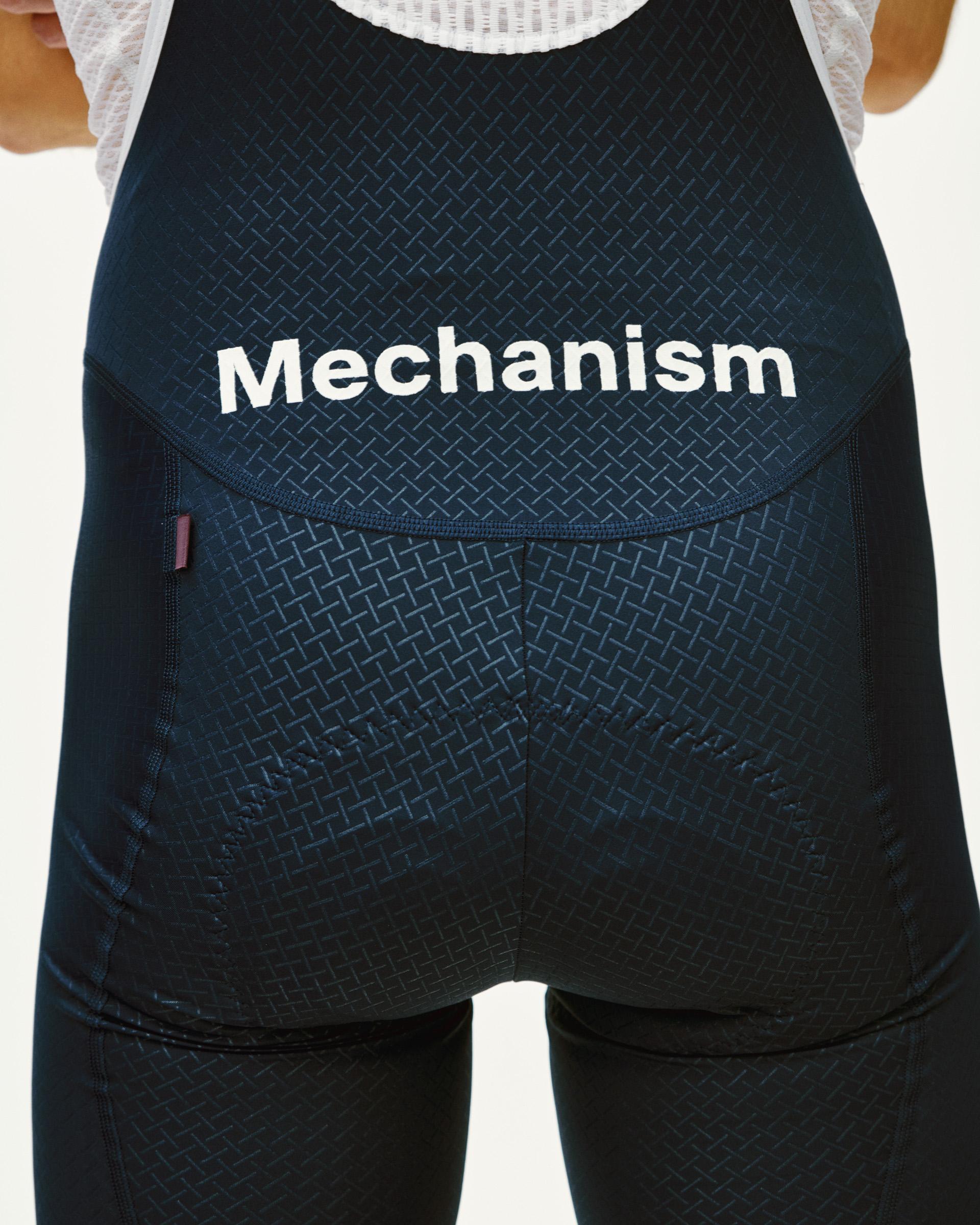 Navy Mechanism cycling bibs, rear view with white logo print and textured fabric panels