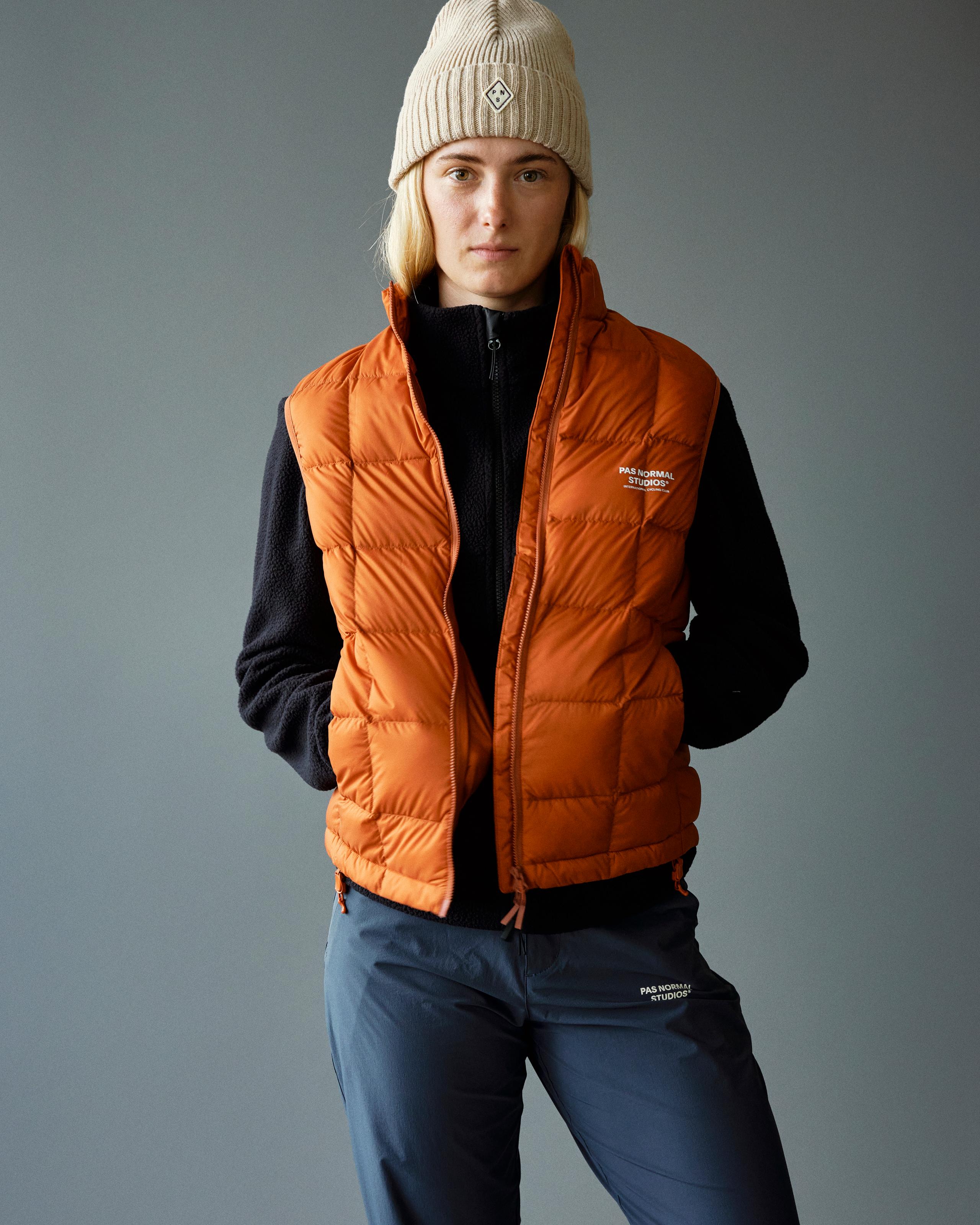 Orange Off-Race Down vest on model, front view with quilted panels and white chest logo