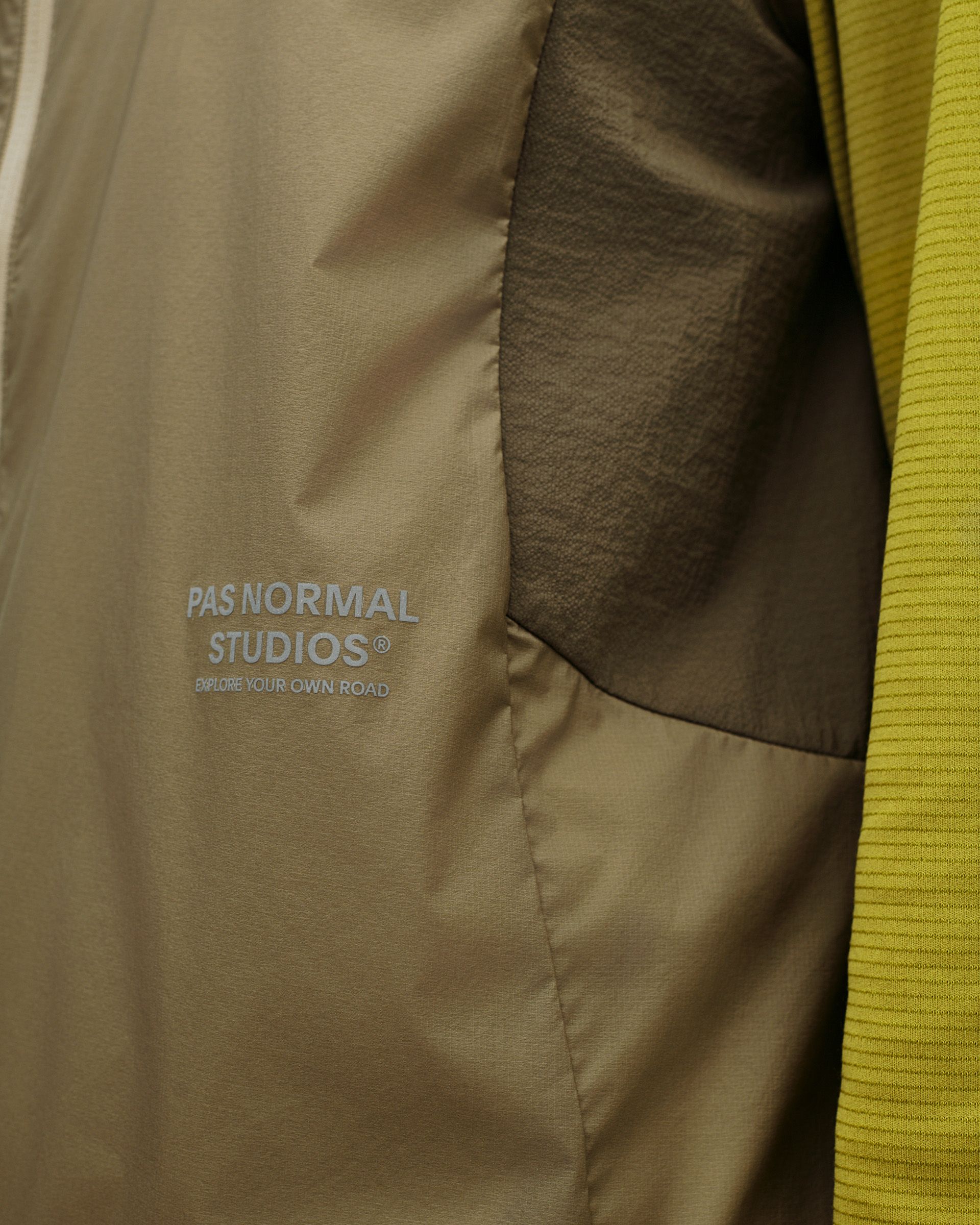 Dusty Earth khaki Balance Windproof cycling vest, interior detail view showing lining and branded logo print