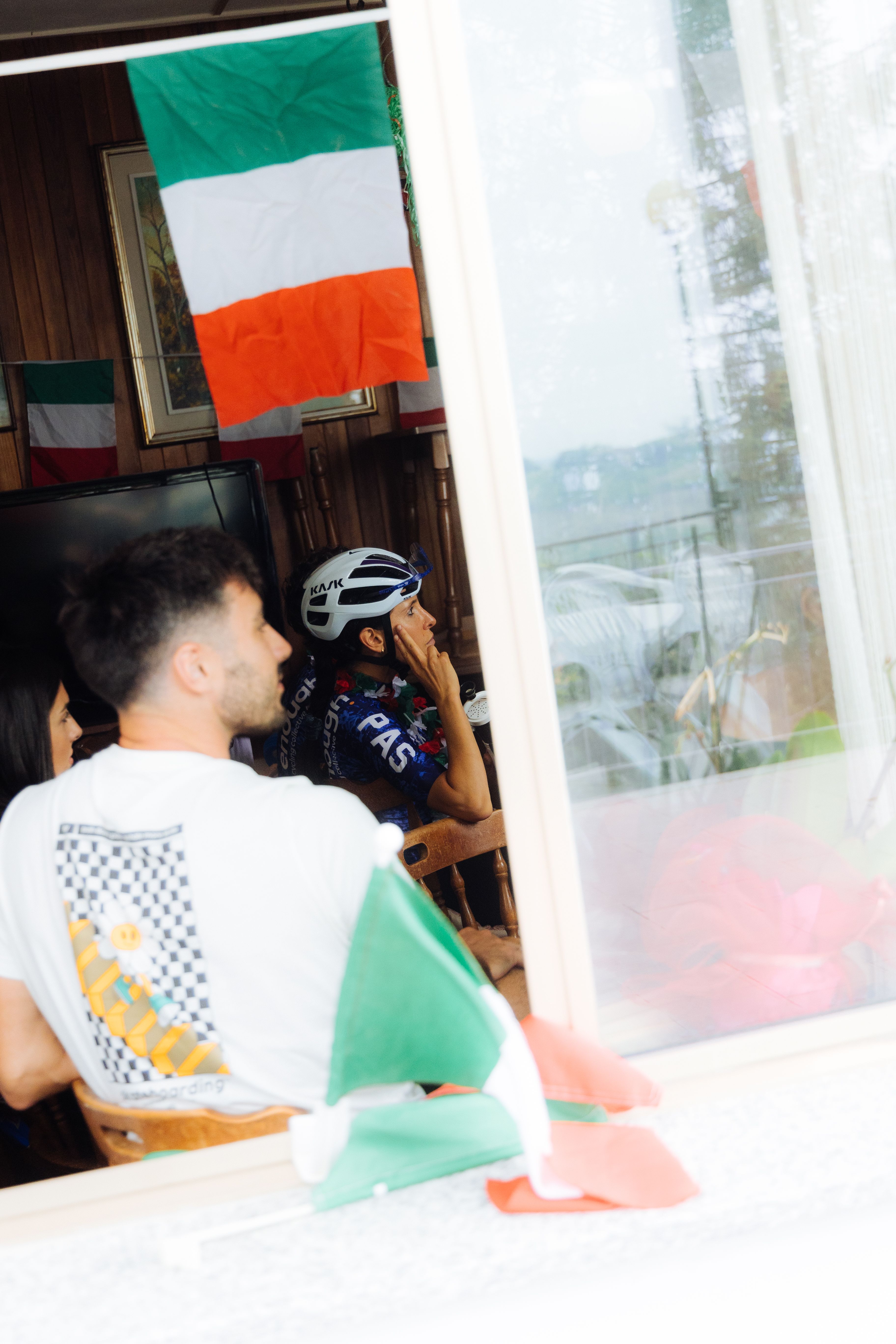 Cyclist in PAS collection jersey indoors with Italian flag, white helmet and checkered pattern visible