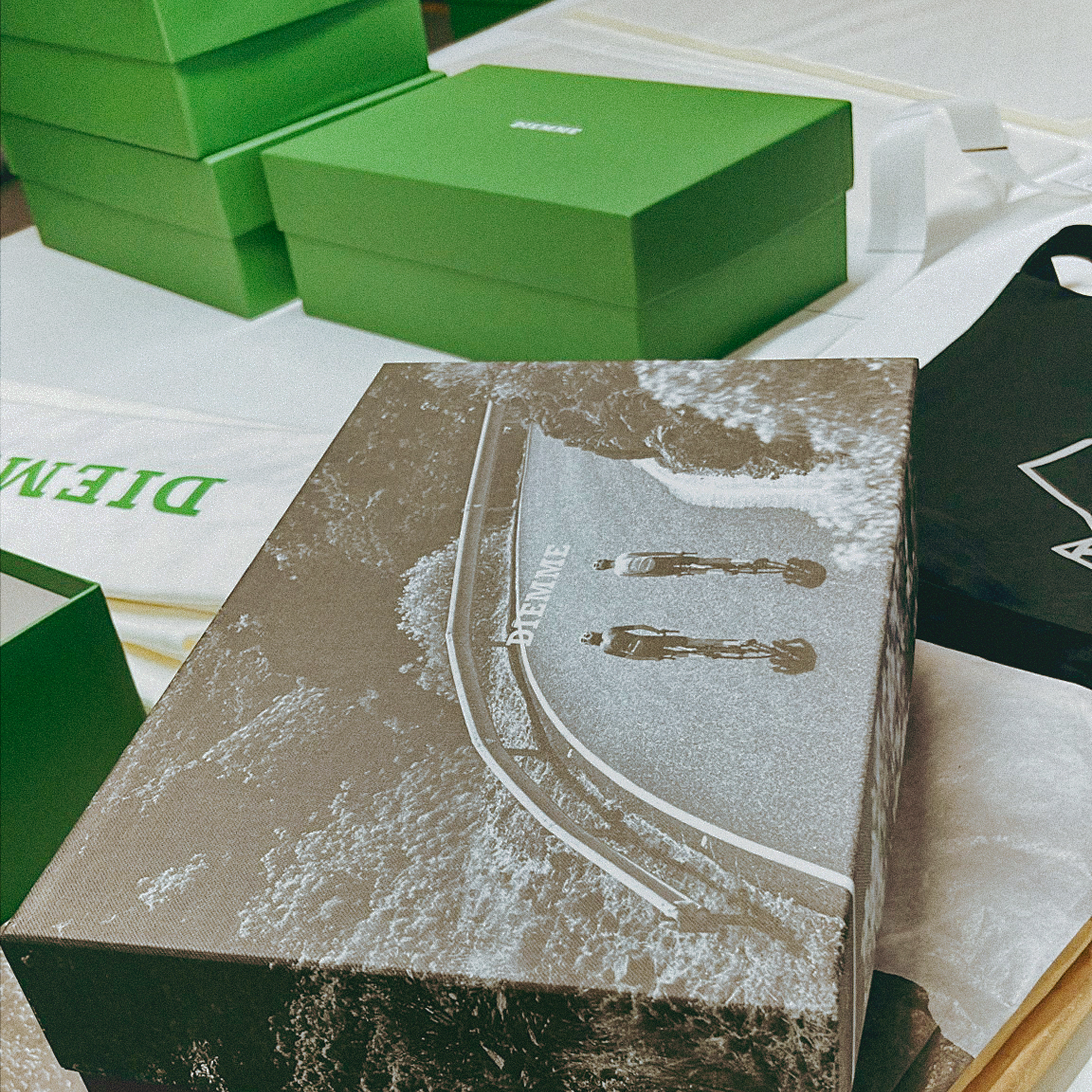 Green and brown shoe boxes with cycling imagery and branding for collaboration collection