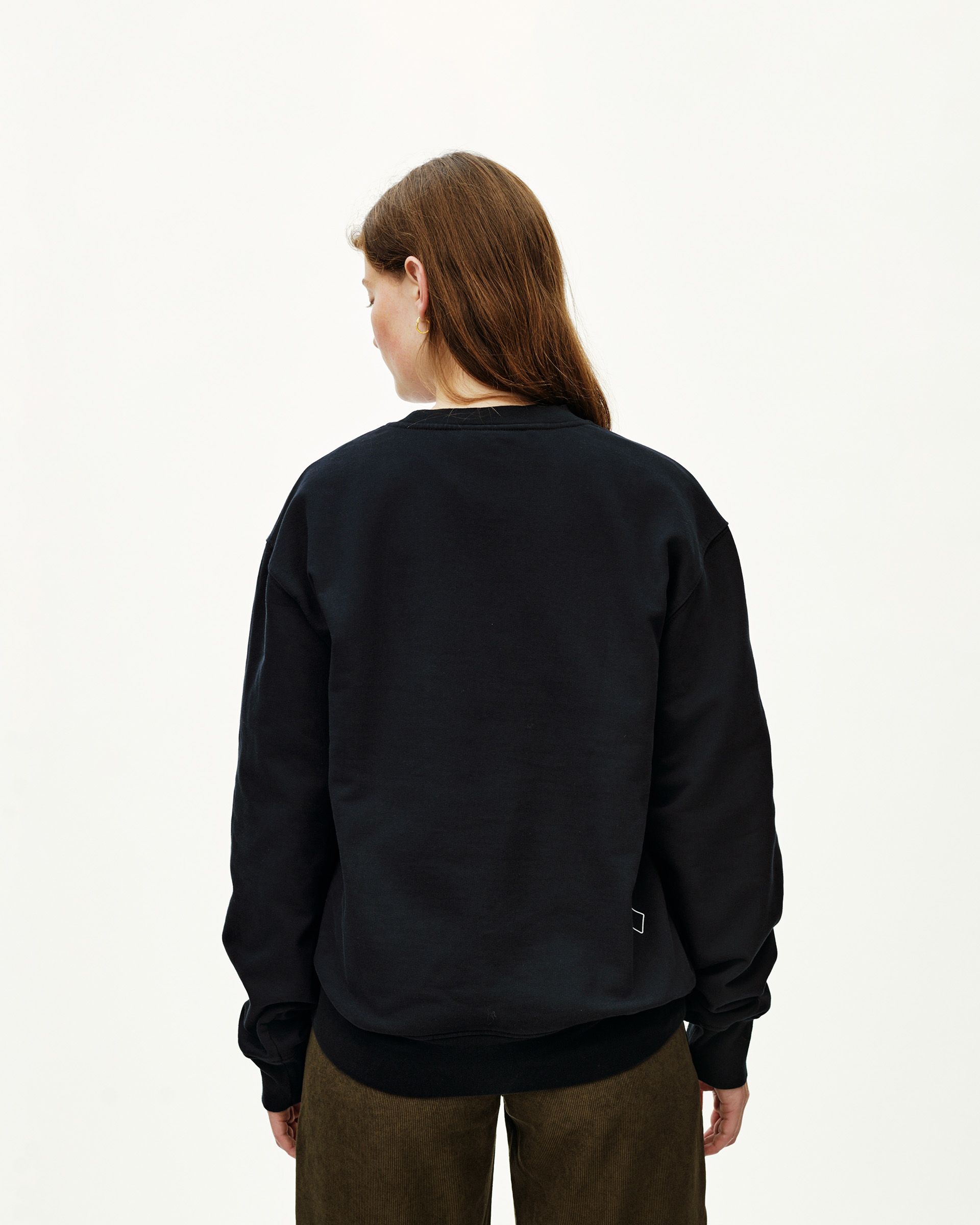 Black Off-Race sweatshirt on model, rear view with small logo patch at hem