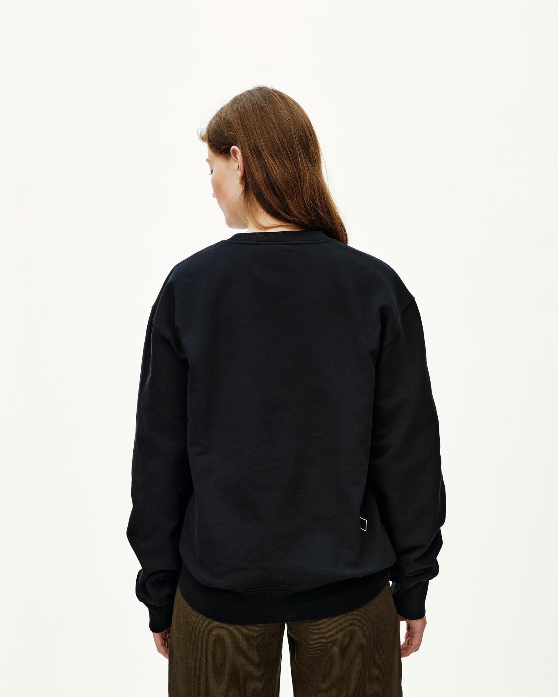 Black Off-Race sweatshirt on model, rear view with small logo patch at hem