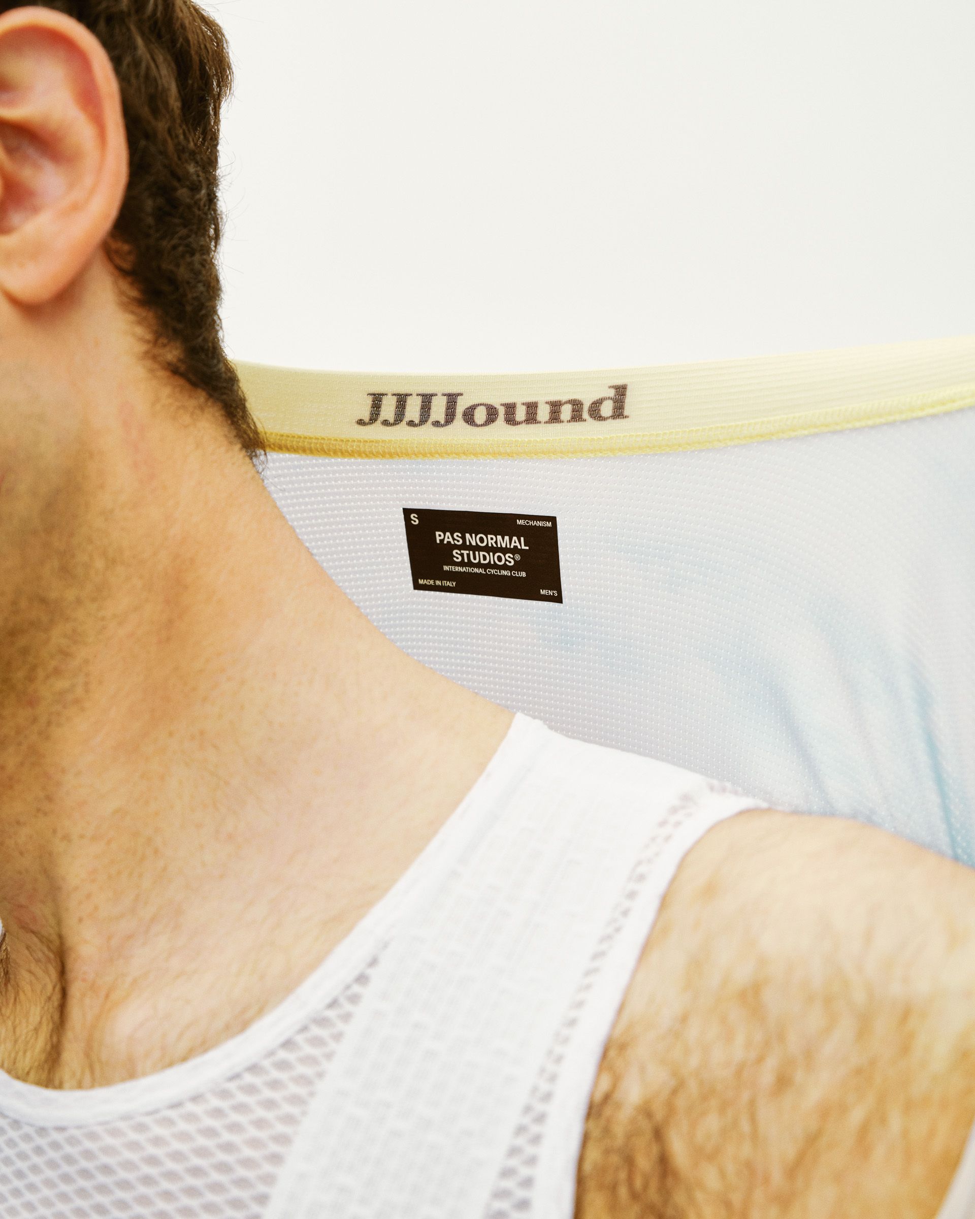 Model wearing white Mechanism jersey with yellow collar trim and brand label detail