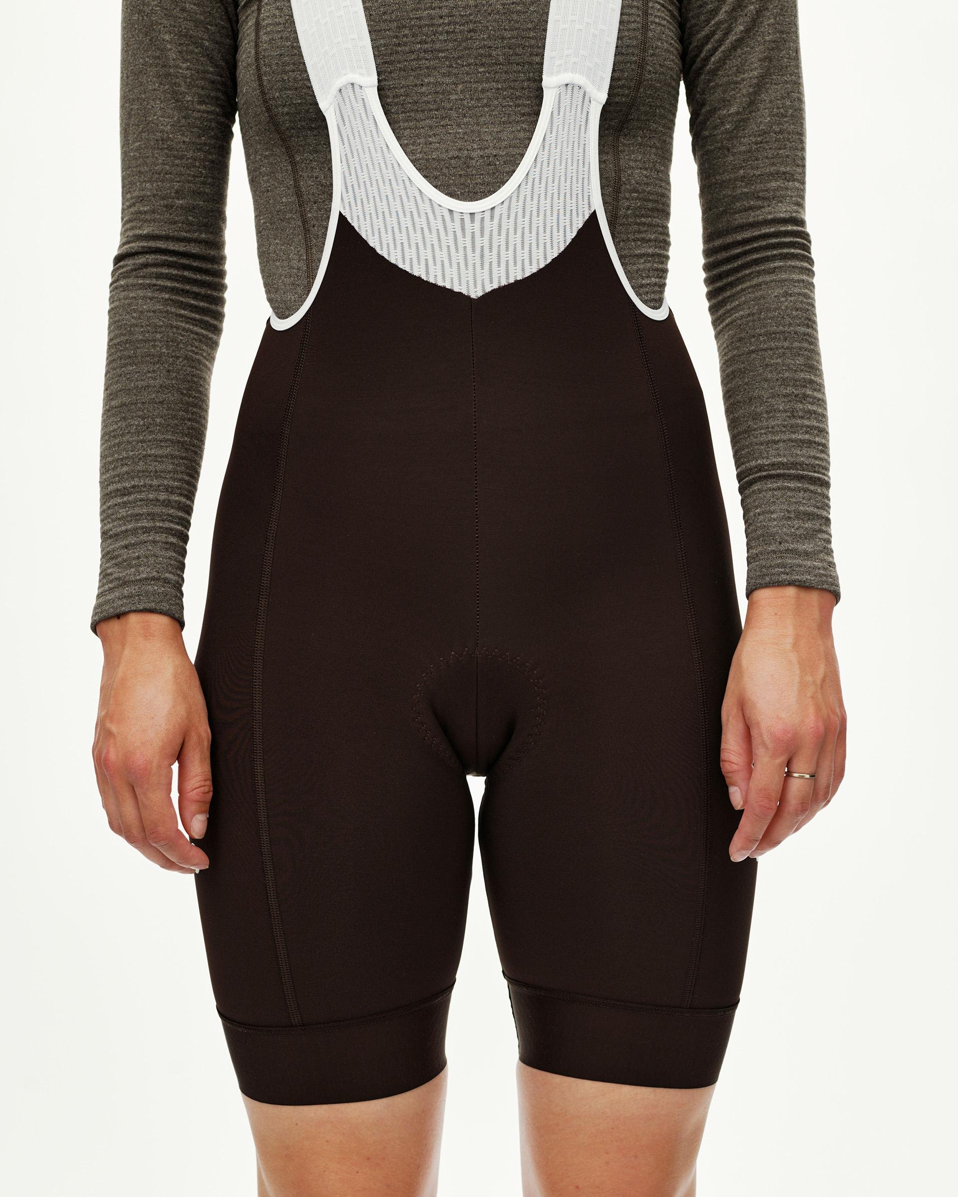 Dark Coffee brown Mechanism Thermal women's cycling bibs, front view on model with white mesh bib straps