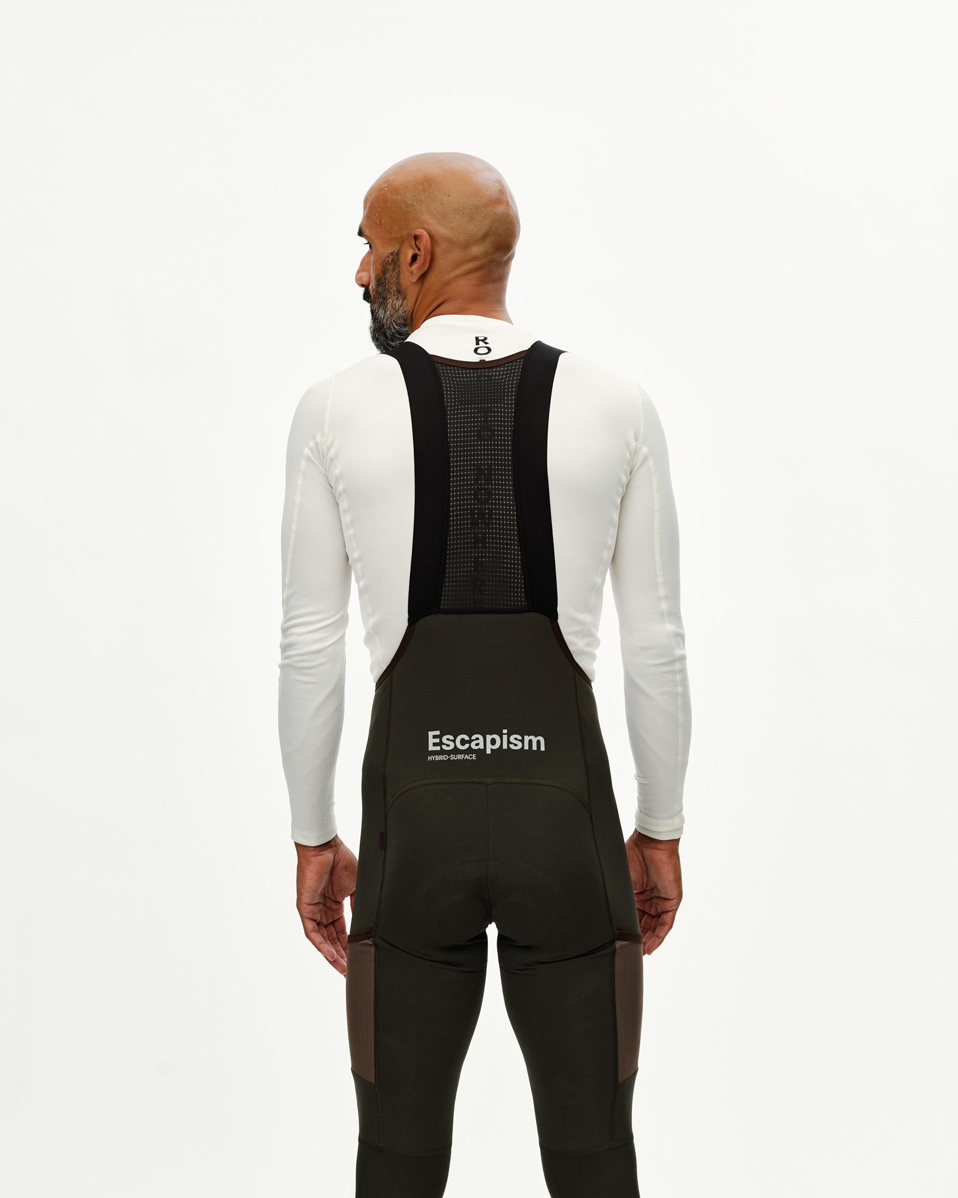 Dark Olive Escapism Long Cargo cycling bibs on model, rear view with black mesh straps and white chest print