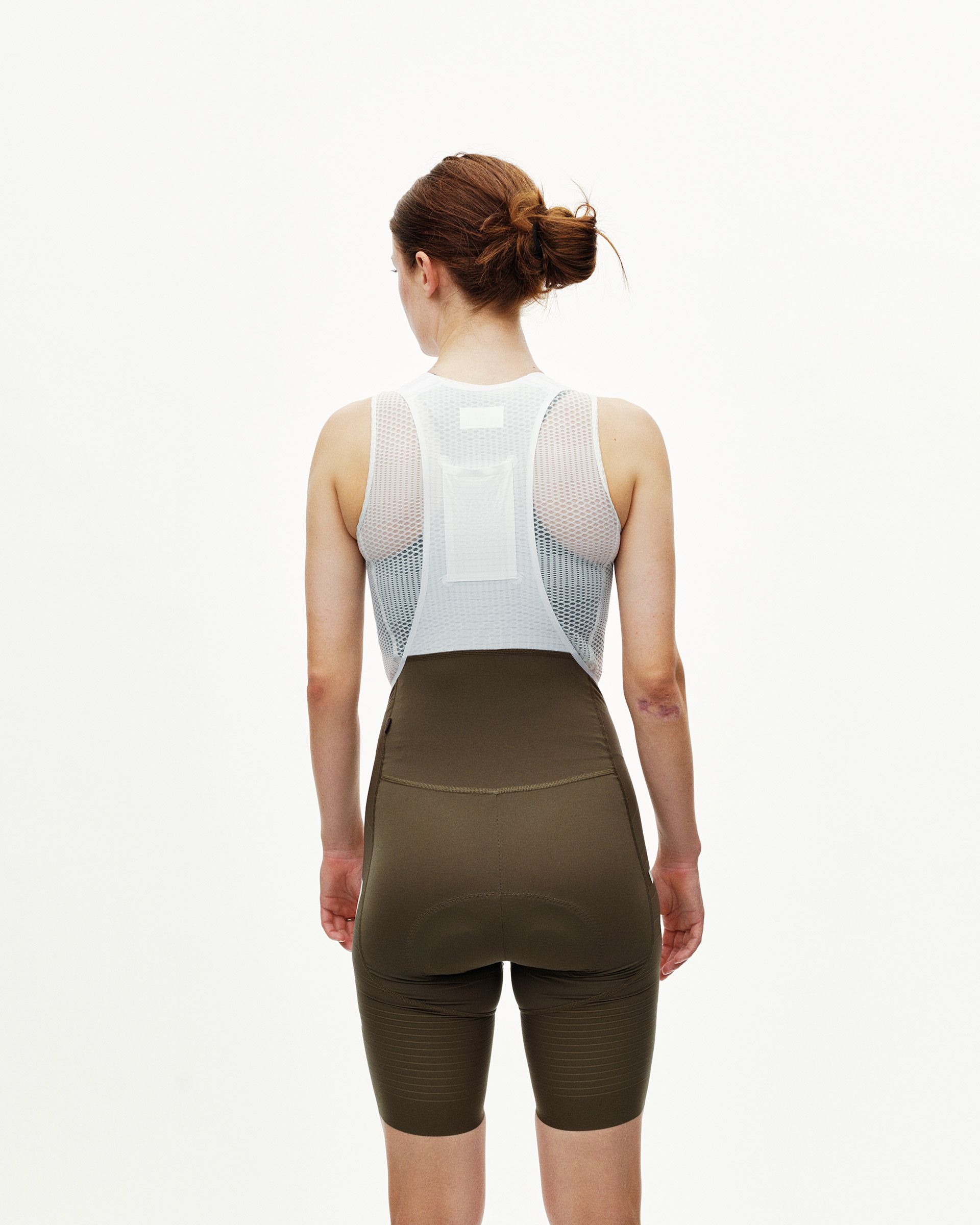 Dark Earth khaki PAS Mechanism Pro women's cycling bibs on model, rear view with white mesh bib straps
