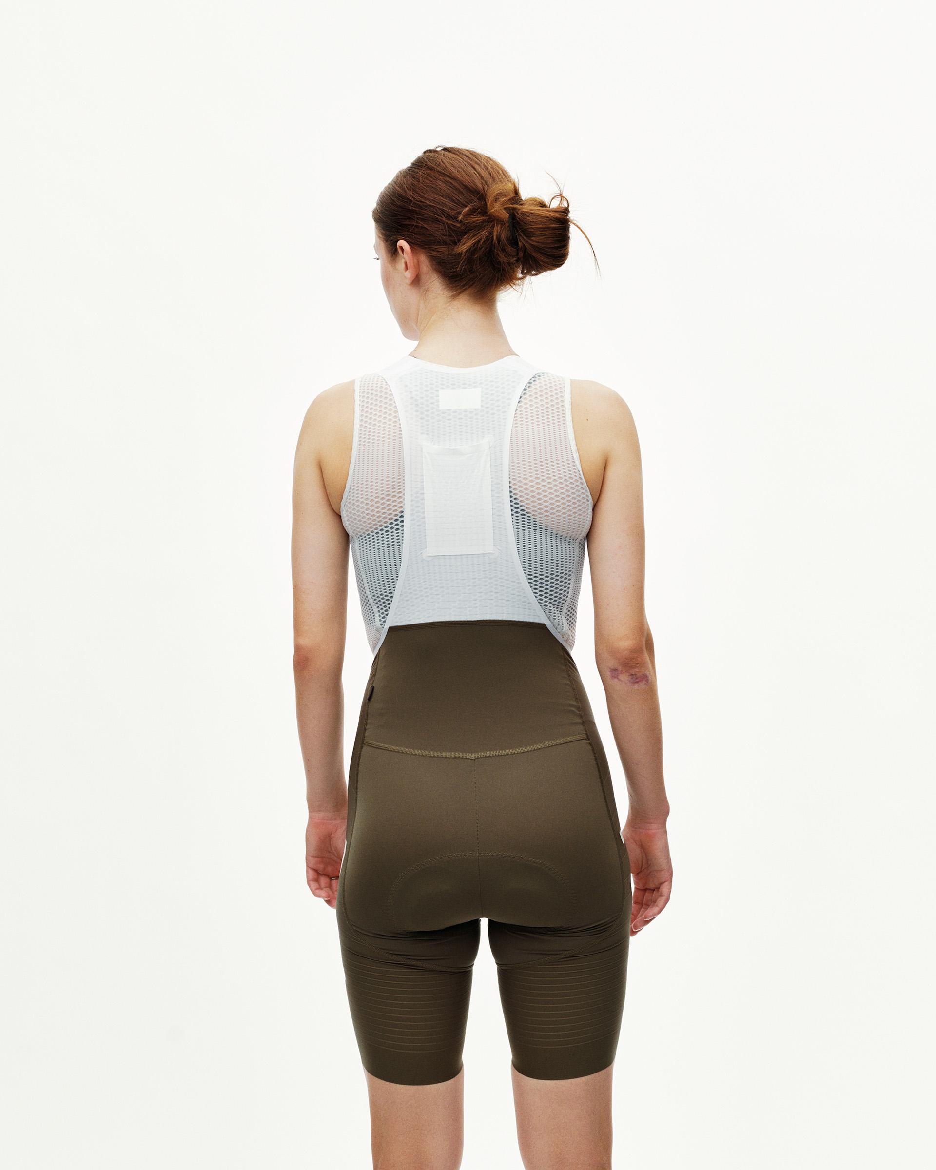 Dark Earth khaki PAS Mechanism Pro women's cycling bibs on model, rear view with white mesh bib straps