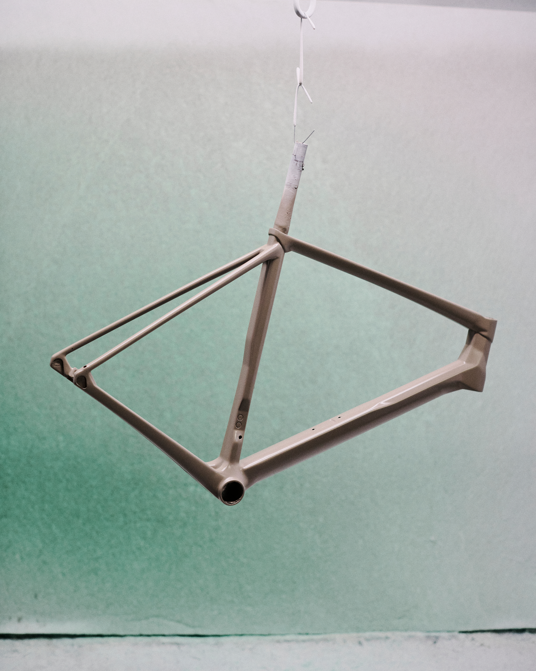 Brown bike frame against gradient green background