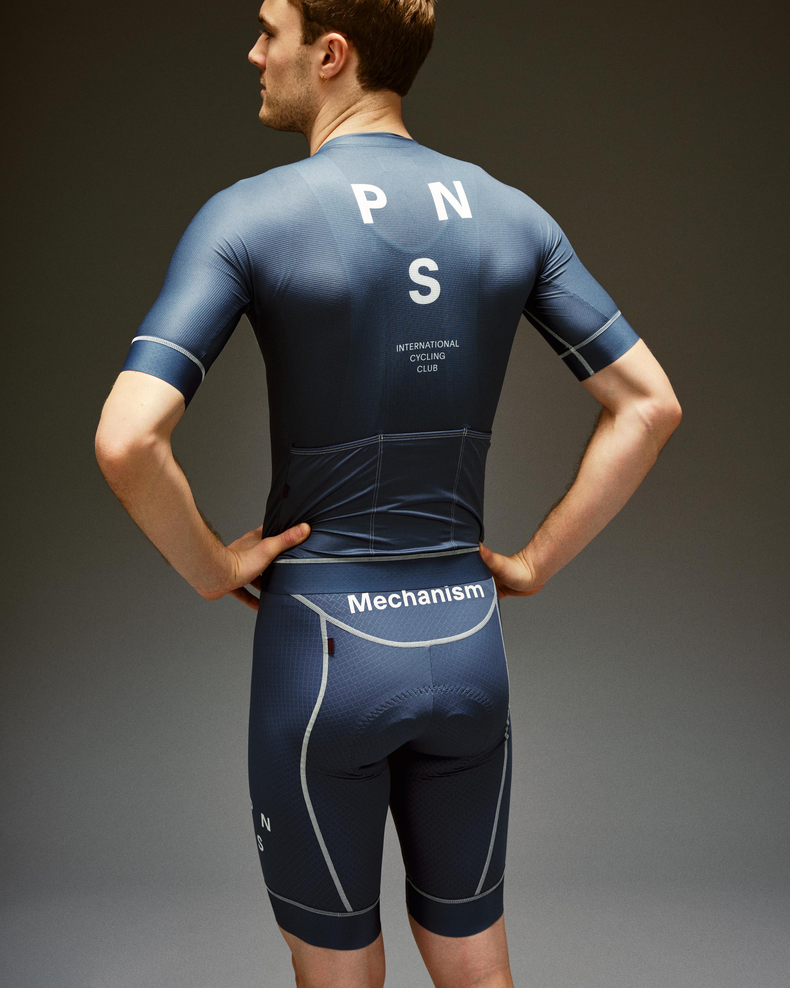 Light Indigo Mechanism cycling bibs on model, rear view with white Mechanism waistband logo and contrast stitching