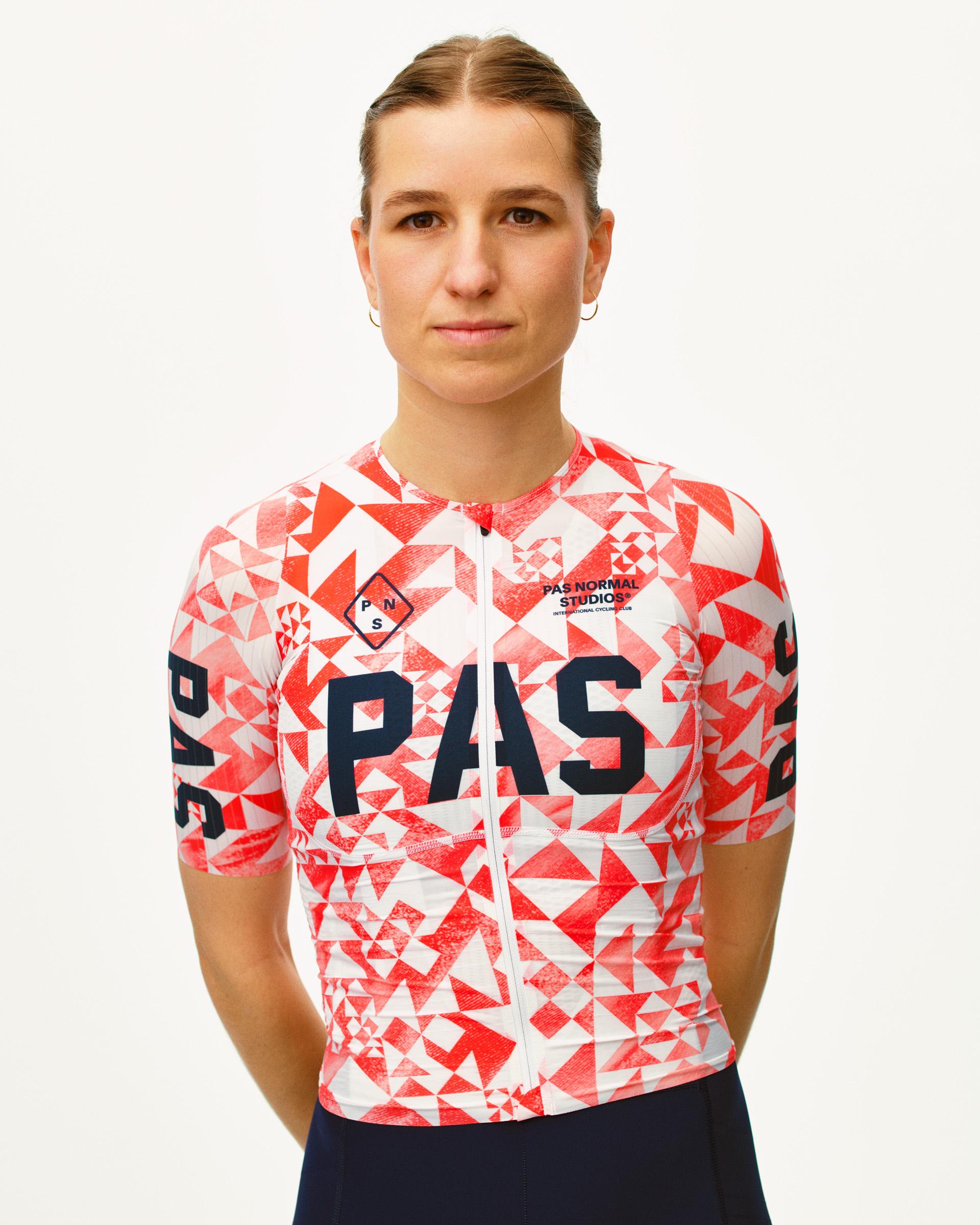 Red PAS Mechanism Pro cycling jersey on model with geometric origami print