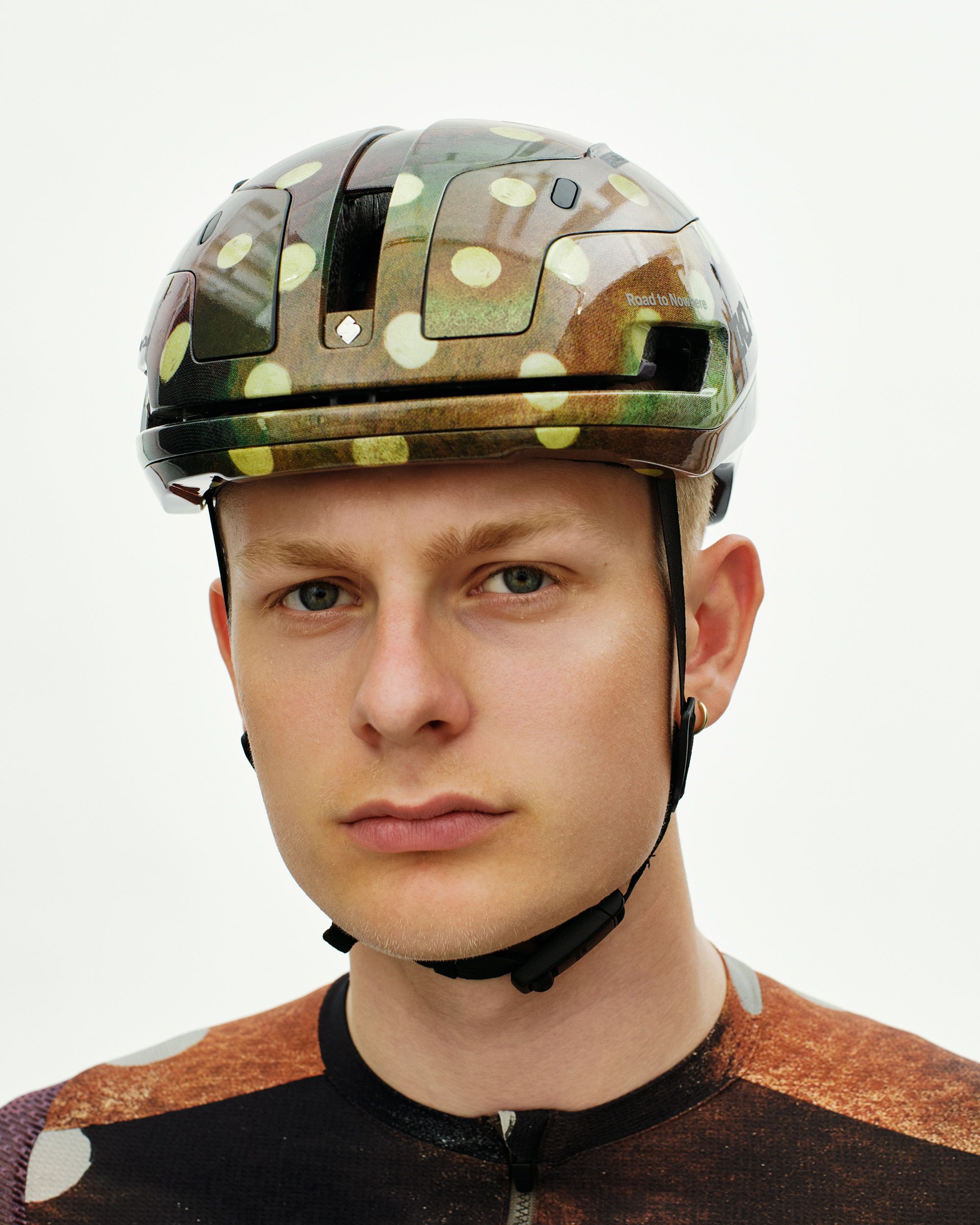 Brown T.K.O. Falconer Aero 2Vi cycling helmet on model with camouflage pattern and yellow dots
