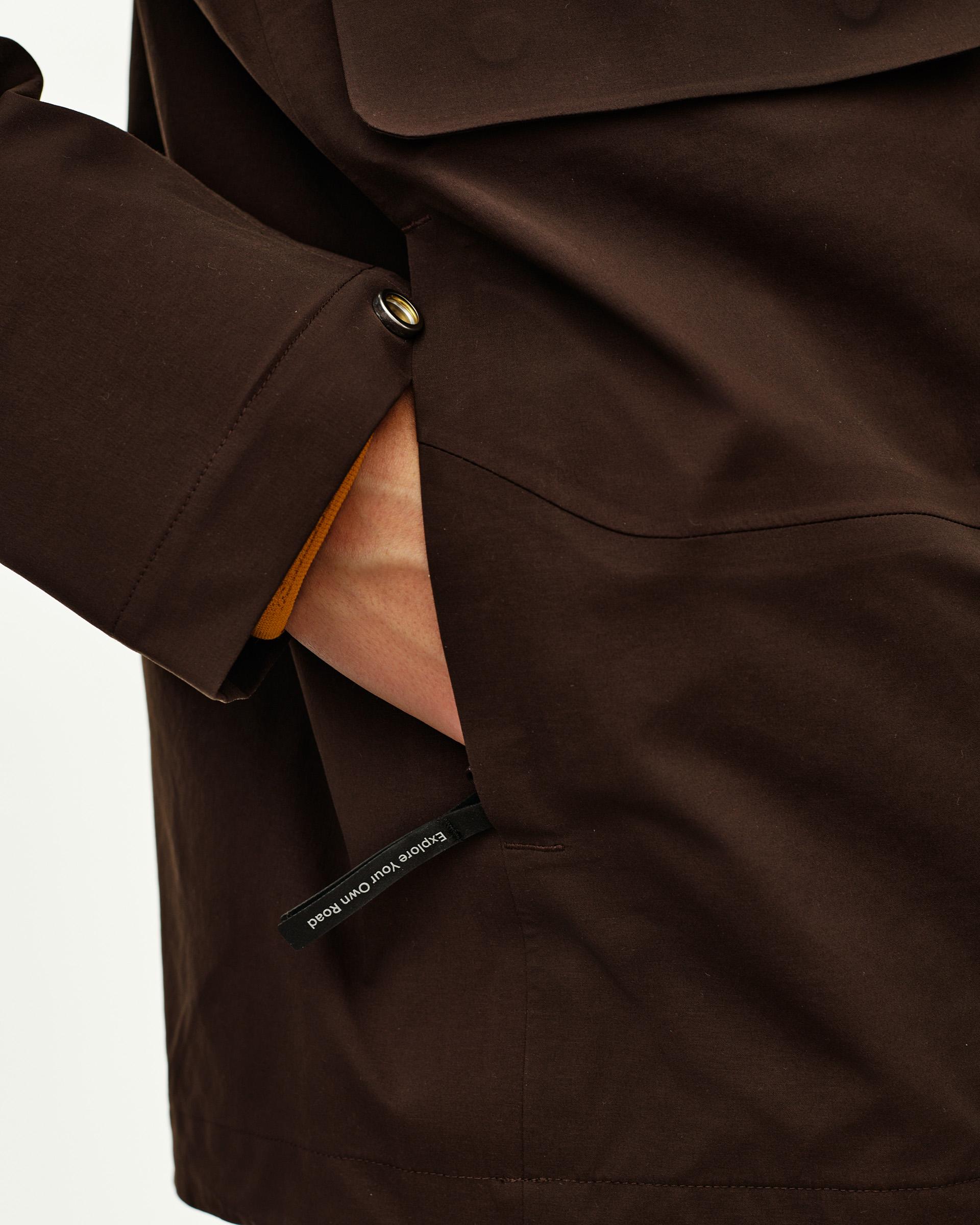 Dark Coffee brown Off-Race 3L Shell jacket, detail view of pocket opening and snap cuff on model
